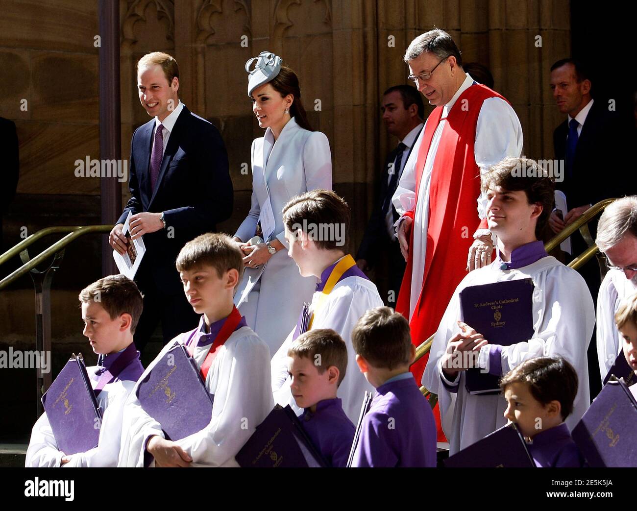 Britain's Prince William (L) and his wife Catherine, Duchess of Cambridge, (2nd L) stand alongside a choir, Archbishop of Sydney Glenn Davies (back C, in red) and Australian Prime Minister Tony Abbott (back R) following Easter Sunday Service at St Andrews Cathedral in Sydney, April 20, 2014. Britain's Prince William and his wife Kate are undertaking a 19-day official visit to New Zealand and Australia with their son George.   REUTERS/Lisa Maree Williams/Pool   (AUSTRALIA - Tags: ENTERTAINMENT ROYALS POLITICS RELIGION) Stock Photo