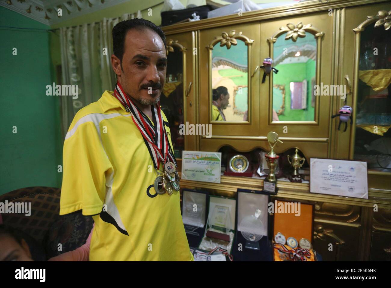 Disabled table tennis champion Ibrahim Hamato, 37, poses with his medals  and award from different tournaments, at his home in Domiat, northeast of  Cairo, September 28, 2014. Having lost both his arms