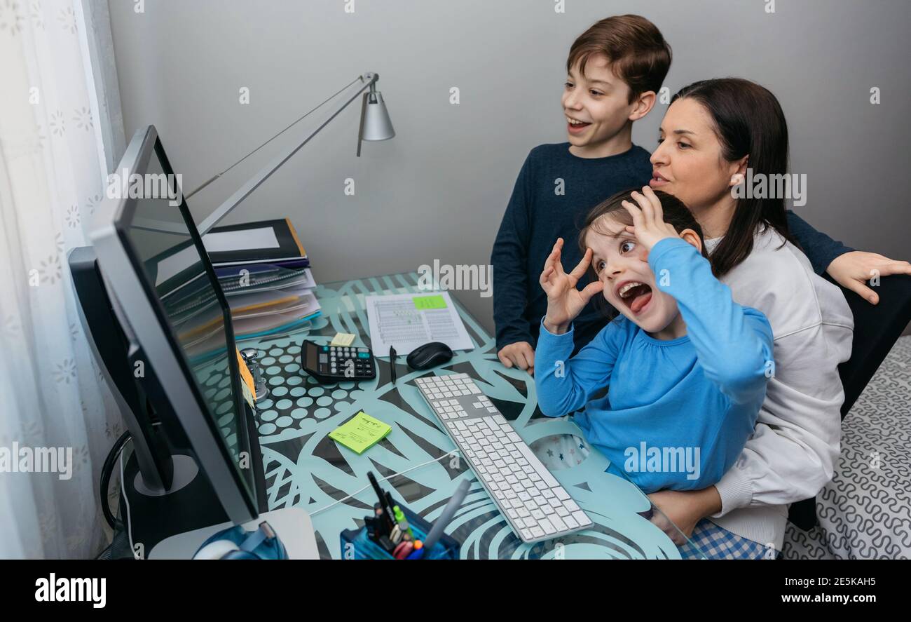 Family talking on video call while the girl grimaces Stock Photo