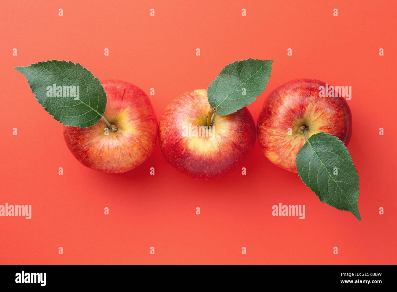 Red apples with leaves over paper background. Gala apple composition. View from above Stock