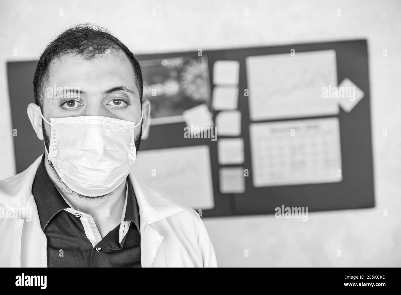 Black and white portrait of doctor wearing protective mask and looking ...