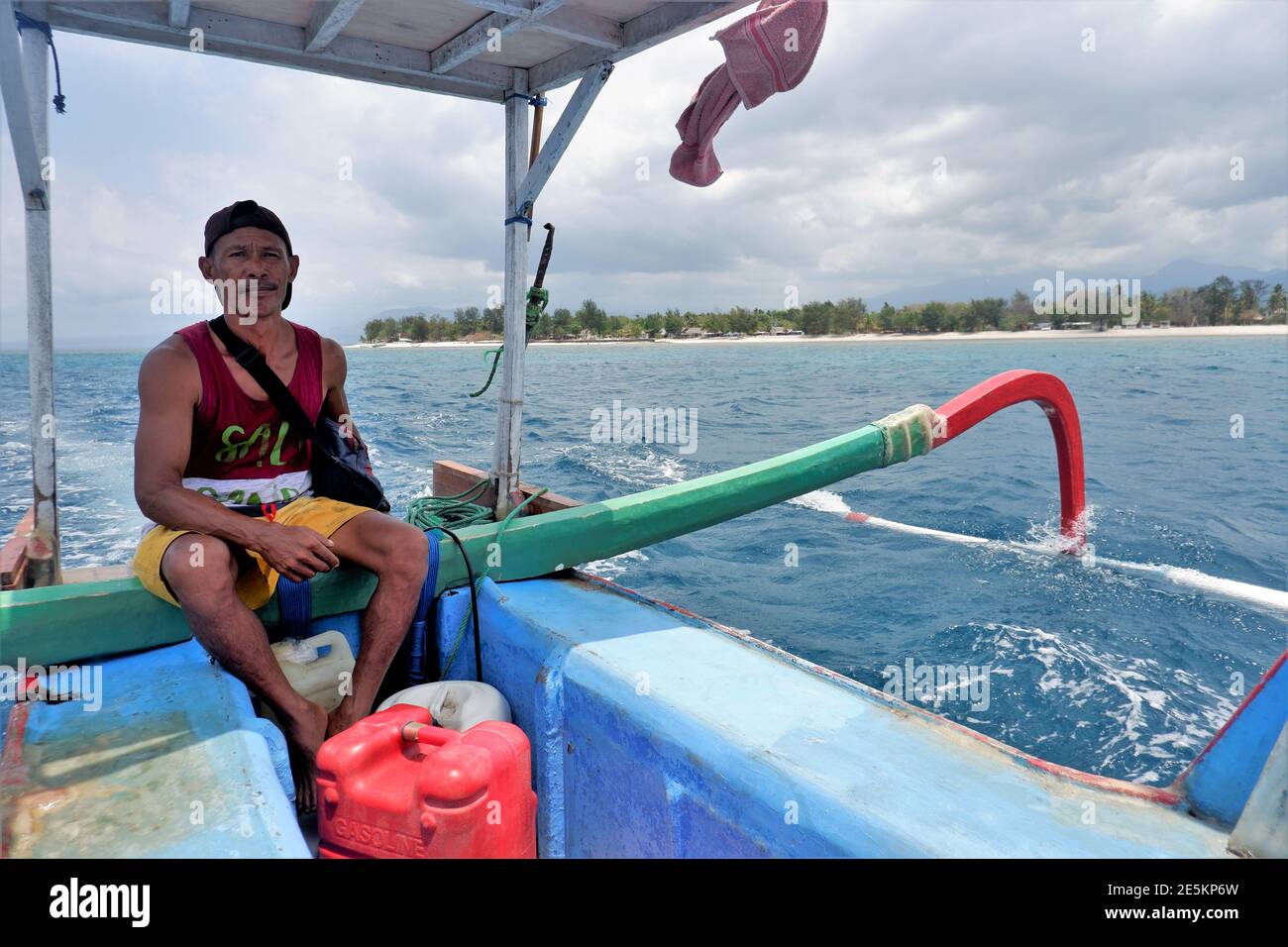 LOMBOK, INDONESIA - OCT 22, 2020: A fisherman is crossing between Gili Trawangan island to Bangsal port with his outrigger boat Stock Photo