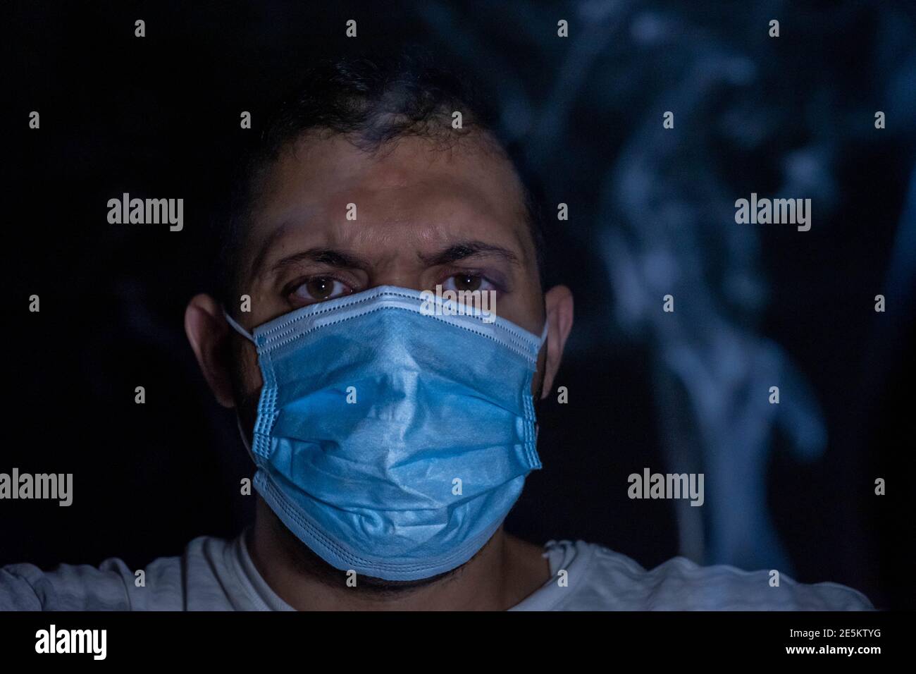 Man in the dark wearing protection mask to protect his breath from ...