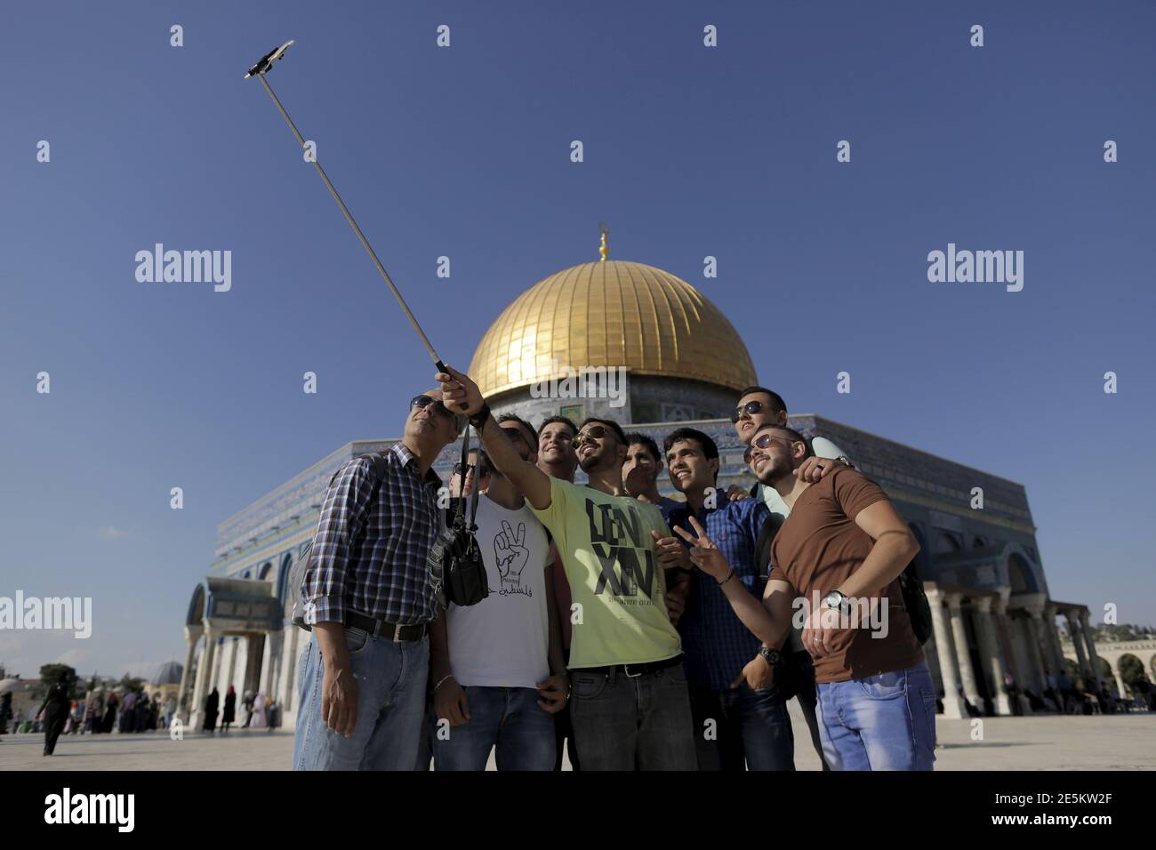 Palestinian Hakem Shtayeh (C), 28, from the West Bank city of Nablus, takes a selfie photo with friends in front of the Dome of the Rock on the compound known to Muslims as Noble Sanctuary and to Jews as Temple Mount, in Jerusalem's Old City, during the holy month of Ramadan, June 29, 2015. This is Shtayeh's first visit to the compound. Palestinians young and old have jumped on a trend for taking 'selfies' at Al Aqsa, the 8th century Muslim shrine in Jerusalem, both as a personal memento and for relatives prevented from or unable to visit the ancient compound. REUTERS/Ammar Awad   PICTURE 7 OF Stock Photo