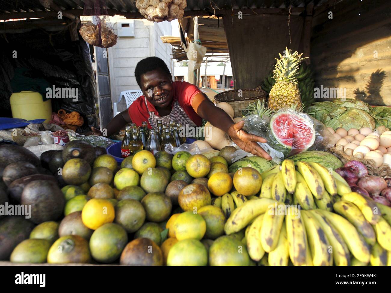 Imelda Akinyi, 25, arranges fruits at her stall in the trading centre of Kogelo, west of Kenya's capital Nairobi, July 14, 2015. Akinyi said, 'President Obama is our son, he clearly knows his roots and he identifies himself with us.' 'We want him to help us get a modern supermarket in Kogelo and find markets for our fruit and vegetables overseas,' she added. As U.S. President Barack Obama visits Kenya, a personal connection to his father's birthplace of Kogelo dominates a trip that Kenyans view as a native son returning home. Residents from a herdsman to a housewife share their views on what O Stock Photo