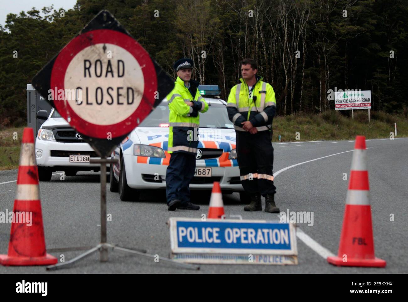 New Zealand policemen stand at a road block on the road leading to the Pike River coal mine November 20, 2010, where 29 miners are trapped following an underground explosion on Friday. New Zealand rescuers have yet to make contact with the trapped miners as fears of lethal gas levels prevented any chance of a rescue on Saturday, 24 hours after the explosion ripped through the remote colliery dug into the side of a mountain.           REUTERS/Tim Wimborne    (NEW ZEALAND - Tags: DISASTER) Stock Photo