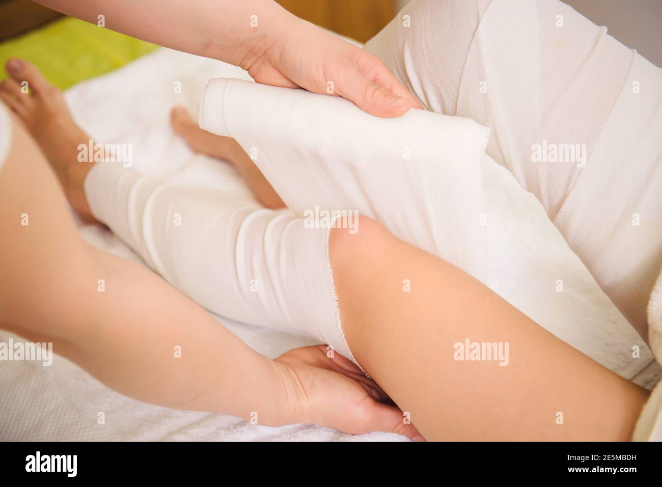 Anti-cellulite and cosmetologist STYX wraps procedure for legs in a spa center. Stock Photo