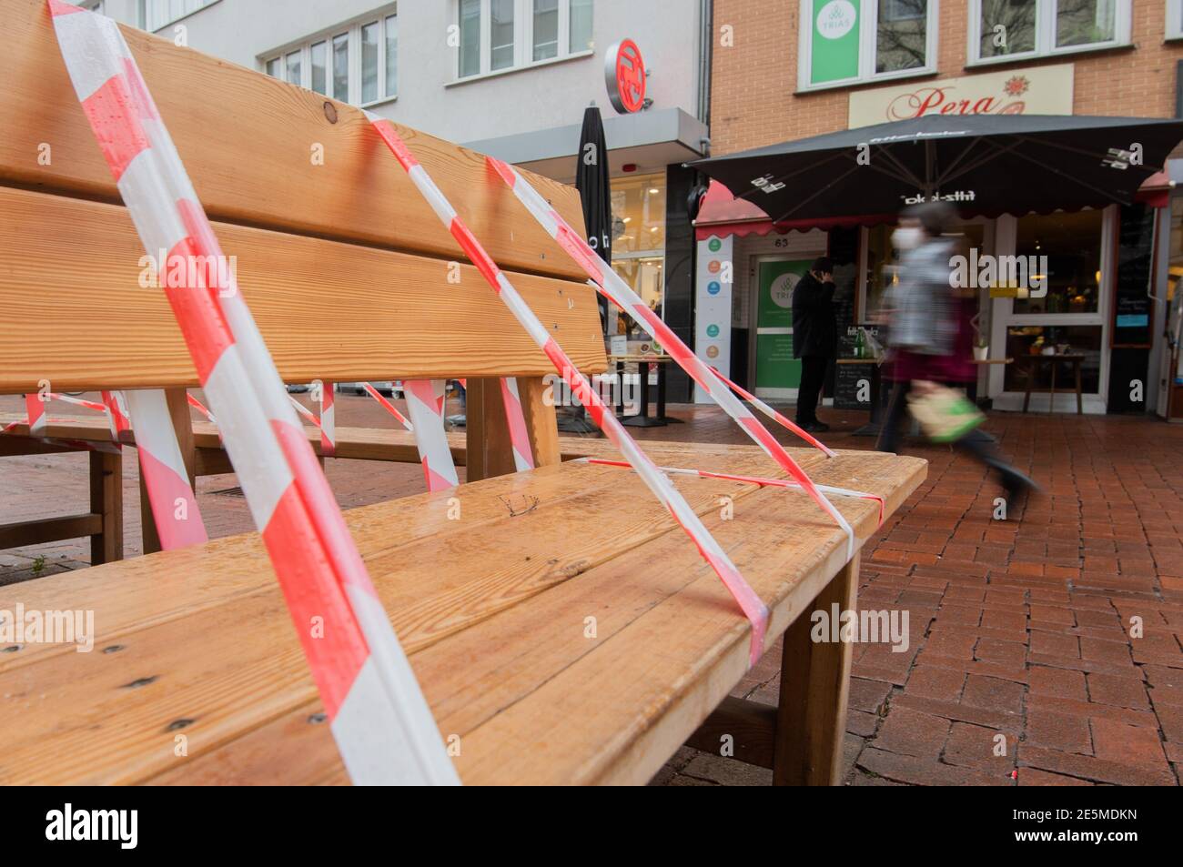 28 January 2021, Lower Saxony, Hanover: Barrier tape hangs on a bench by a tree on the Lister Meile for the Corona pandemic. Photo: Julian Stratenschulte/dpa Stock Photo