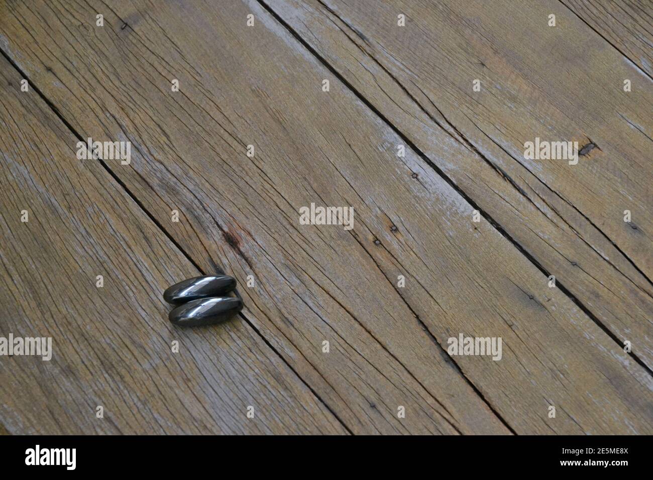 Magnet or magnet. Two units of a ima or magnet in a bright dark color, on an old wooden background, with copy space. Stock Photo