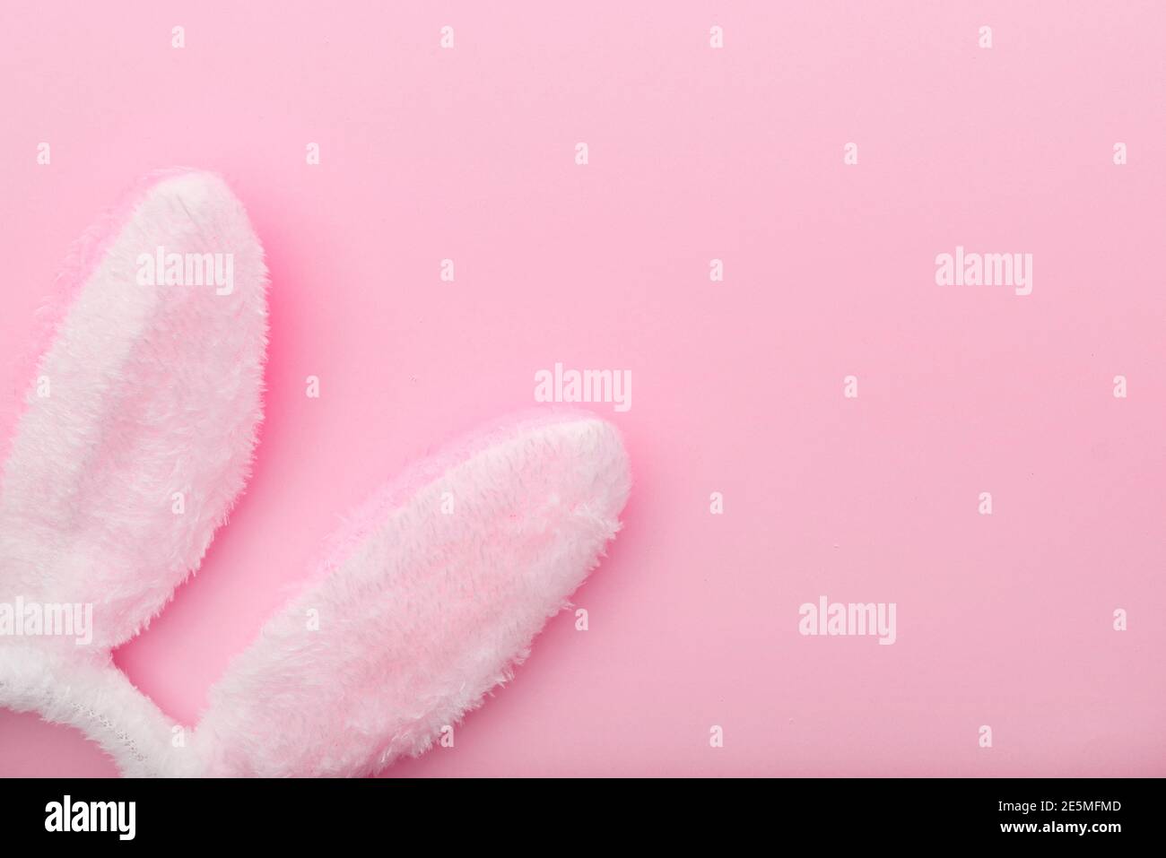 White rabbit ears on pink background, Easter minimal flat lay, top view, space for text Stock Photo