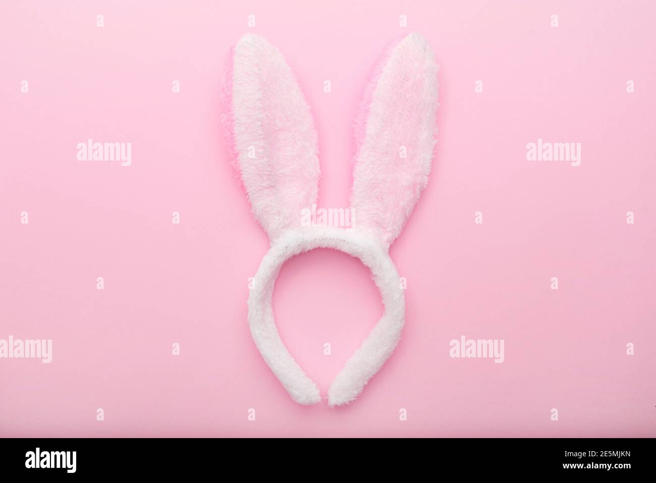 White rabbit ears on pink background, Easter minimal flat lay, top view, space for text Stock Photo