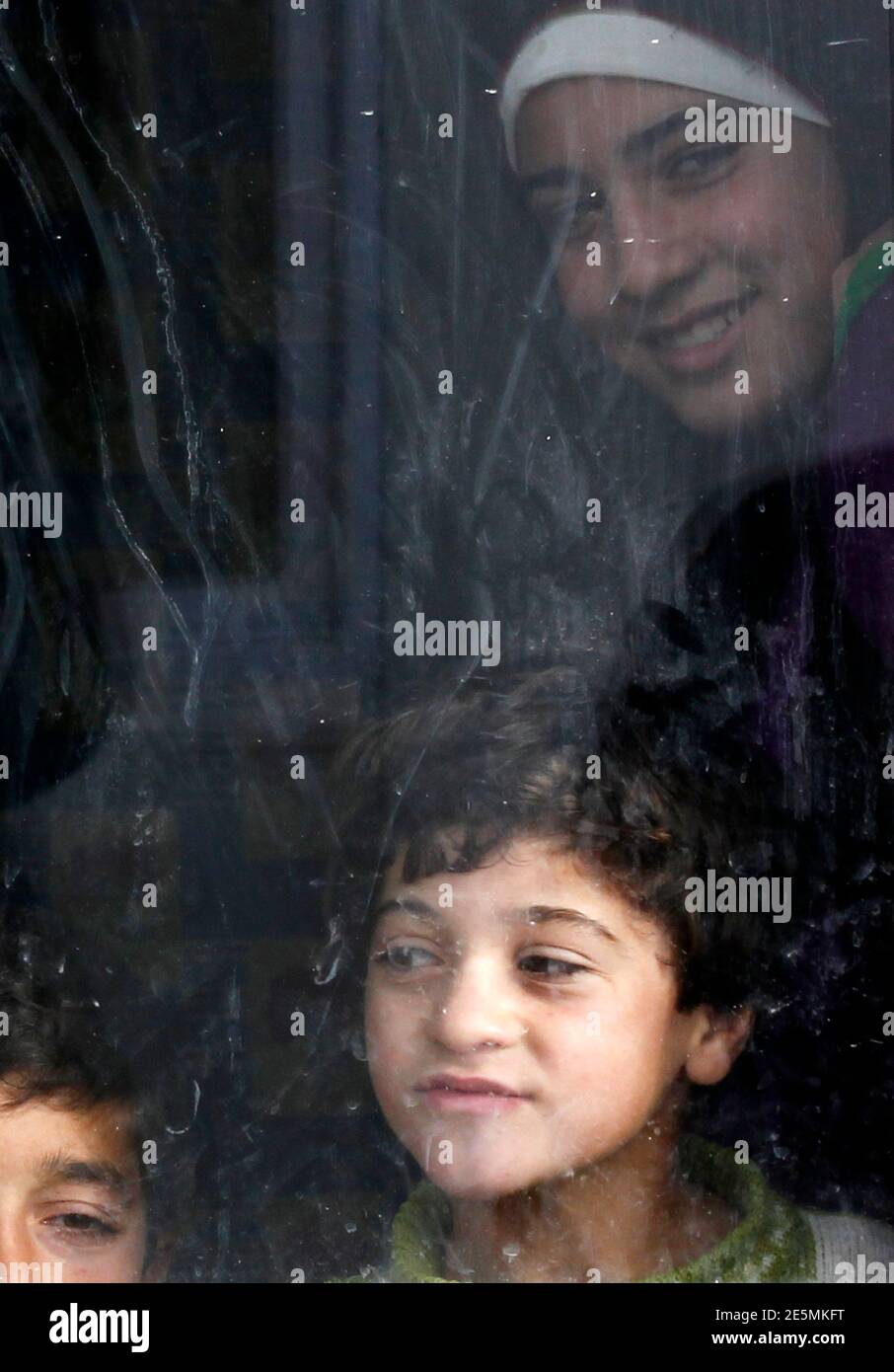 Ruba, 13, (rear), Semiha, 5 (R) and Mahmoud, 14 (L) Araby look out from their container in a