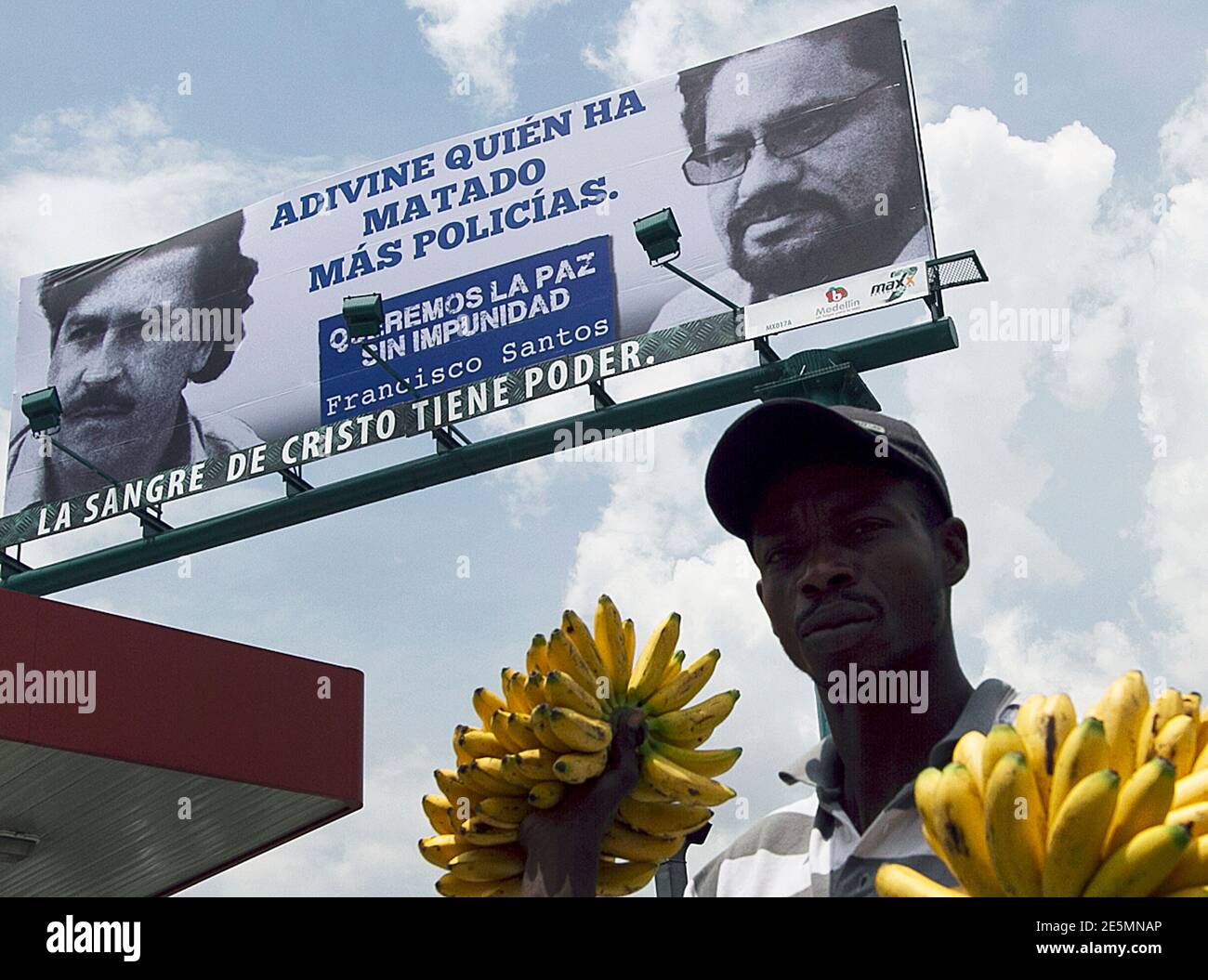 A banana vendor walks past under a political hoarding comparing drug lord  Pablo Escobar (L) with the leader and chief negotiator of the Revolutionary  Armed Forces of Colombia (FARC) Ivan Marquez, on