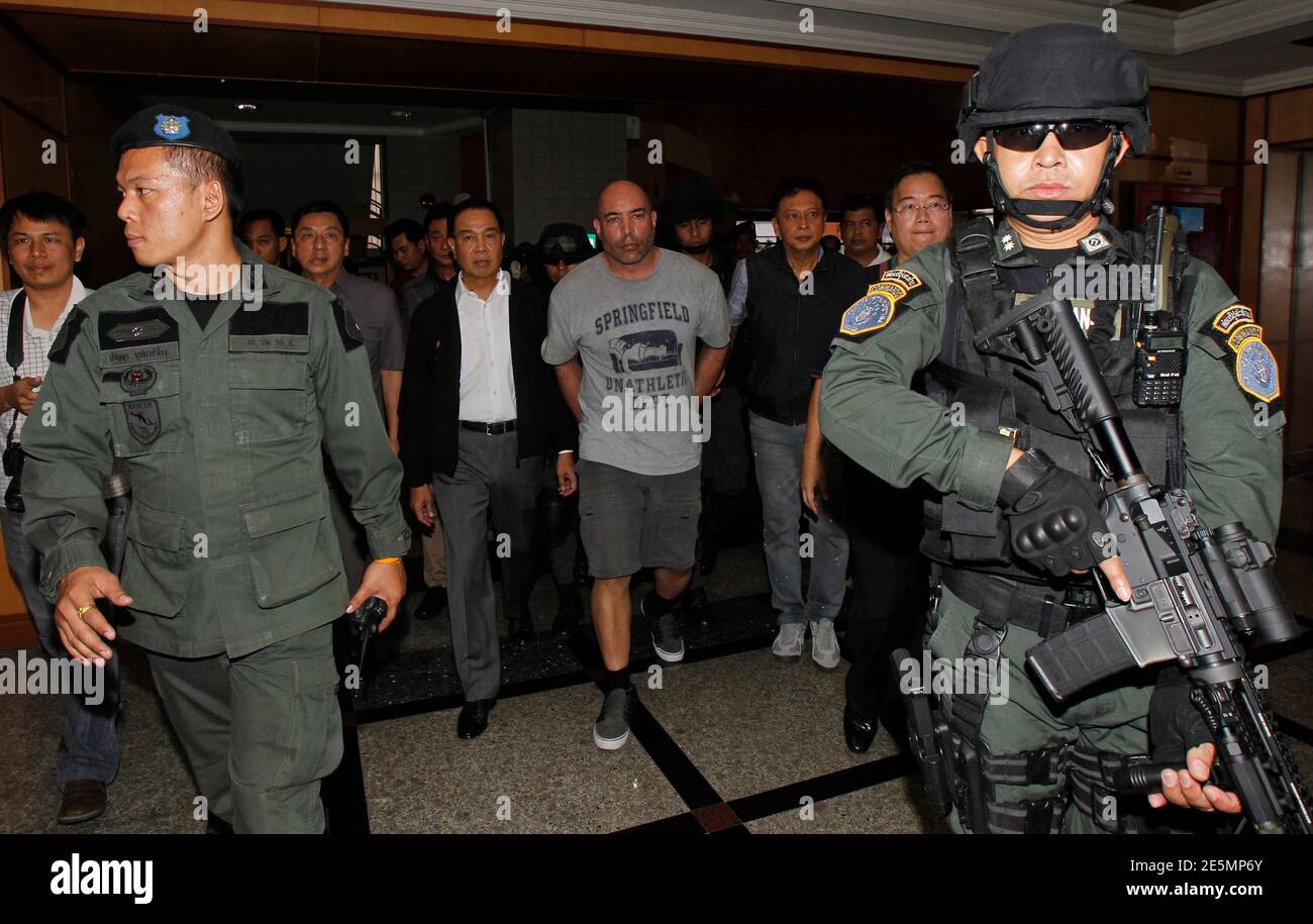 Thai policemen escort American drug suspect Joseph Hunter, 48, at Don Mueang International Airport in Bangkok September 27, 2013. Thai police transferred six foreigners suspected of drug smuggling to Bangkok on Thursday after their arrests in the seaside resort, Phuket. Hunter, along with two British, a Taiwanese, a Slovak, and a Filipino were arrested on Phuket island on Wednesday following a tip-off from the United States Drug Enforcement Administration (DEA). REUTERS/Chaiwat Subprasom (THAILAND - Tags: CRIME LAW DRUGS SOCIETY) Stock Photo
