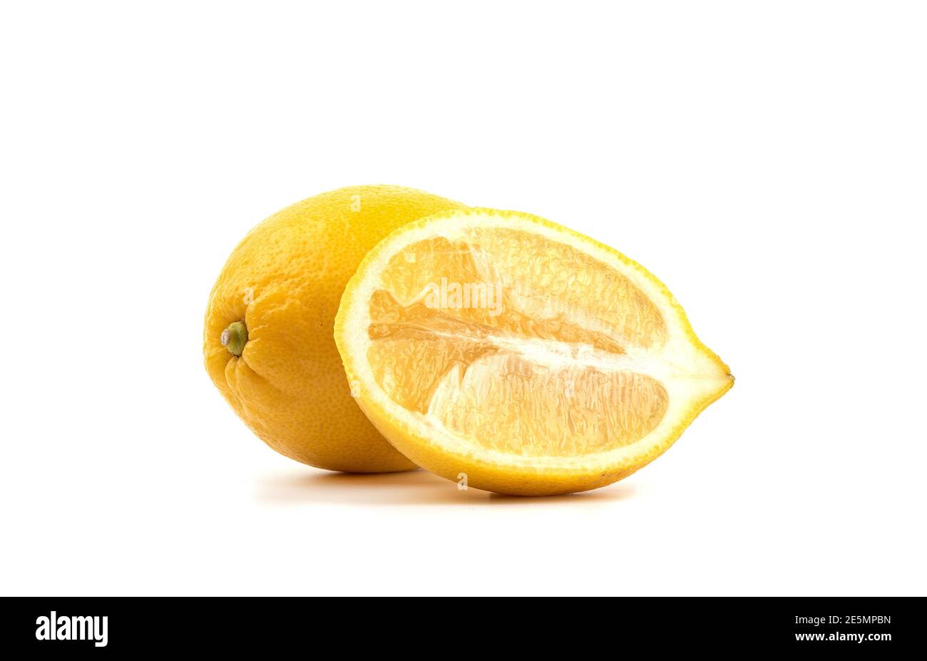 A whole lemon and half of the fruit cut lengthwise on a white