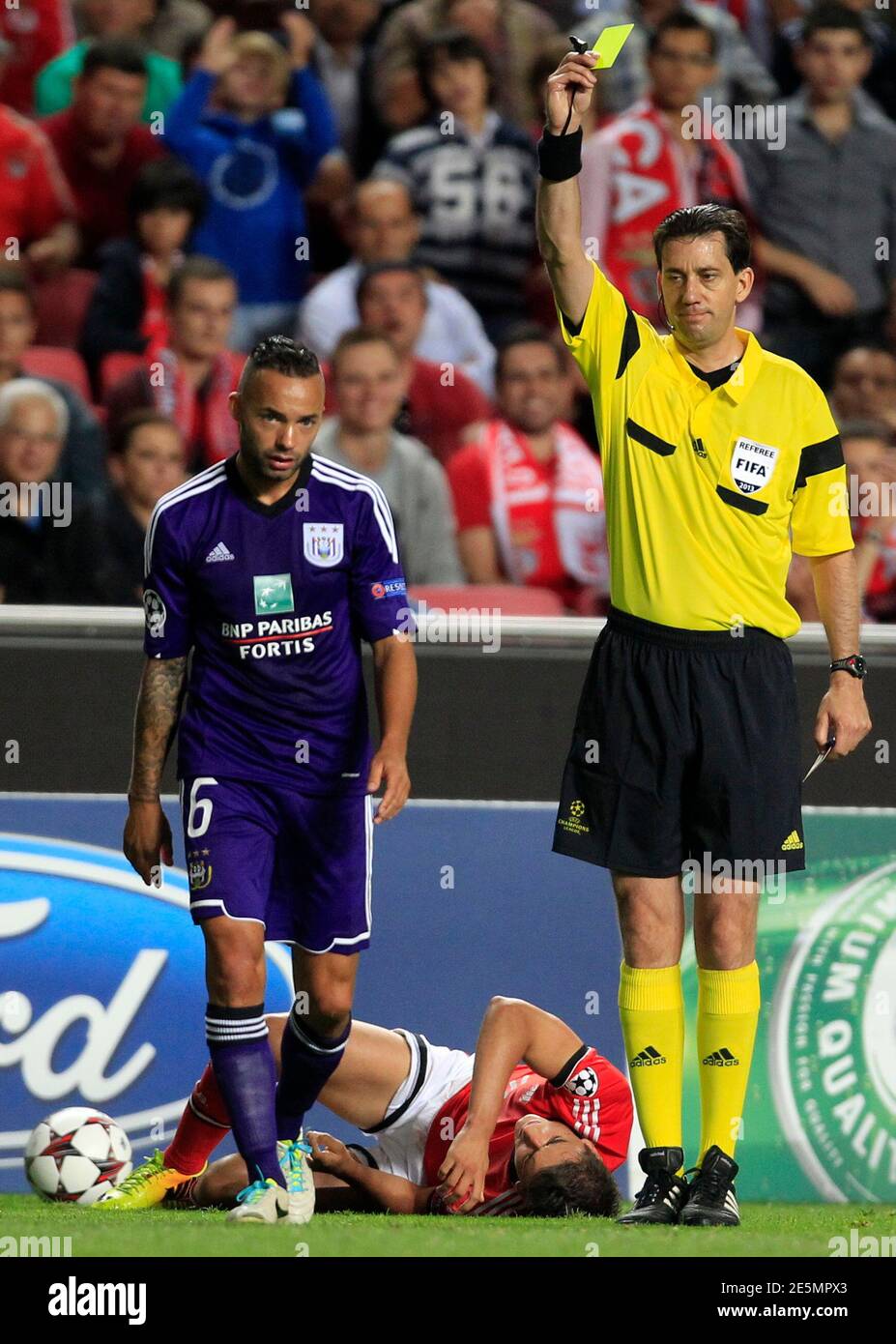 Referee Manuel Grafe R Of Germany Shows A Yellow Card To Anderlecht S Demy De Zeeuw L As Benfica S Filip Djuricic Lies On The Ground During Their Champions League Soccer Match At The