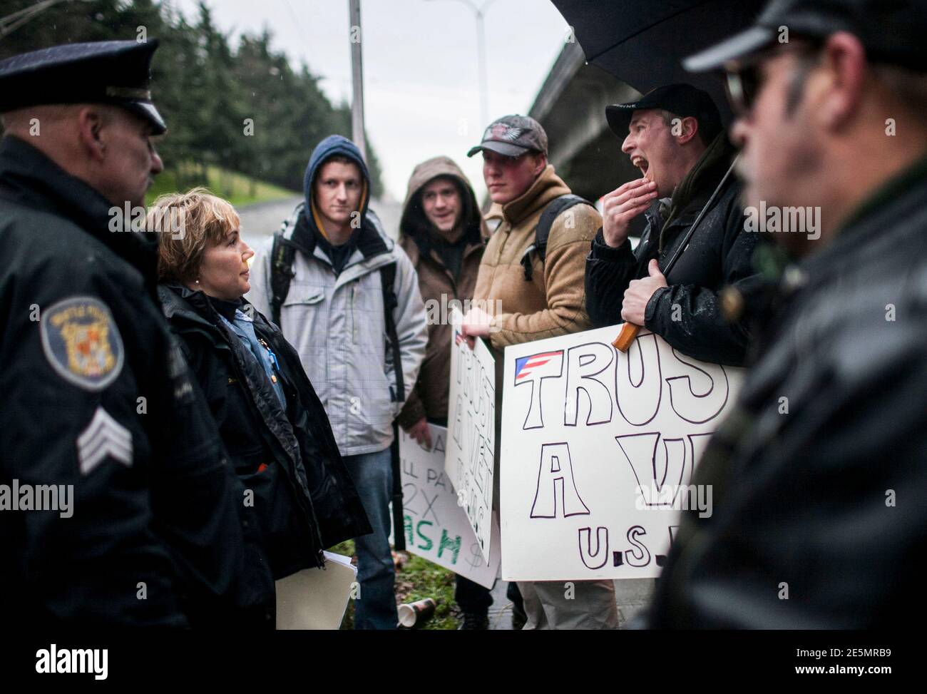 Seattle Police Department Officers talk with a group of gun buyers outside  a gun buyback event in Seattle, Washington January 26, 2013. Participants  received up to a $100 gift card in exchange