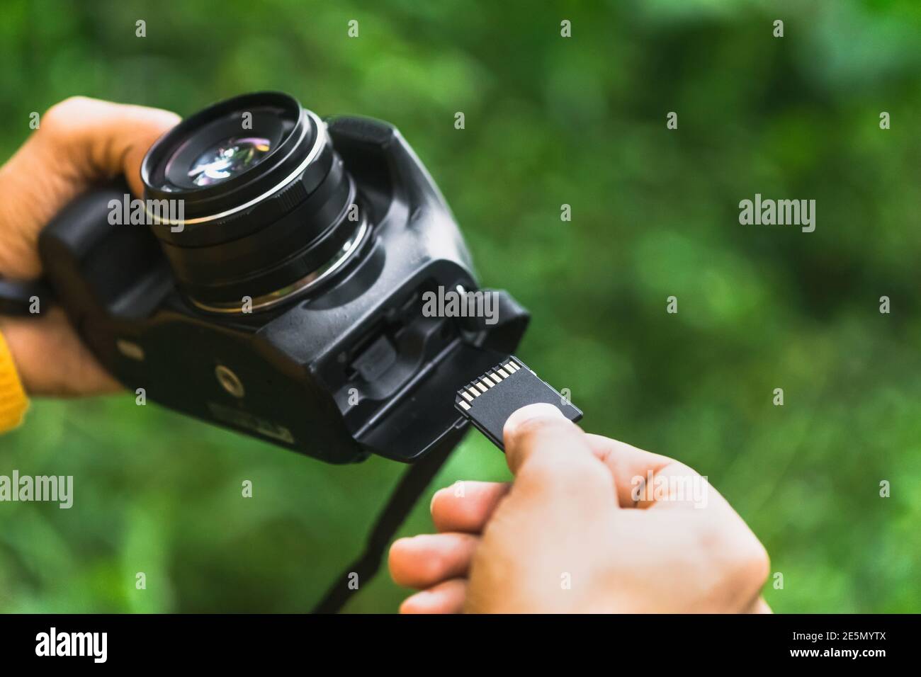 Photographer inserting the memory card into the camera Stock Photo
