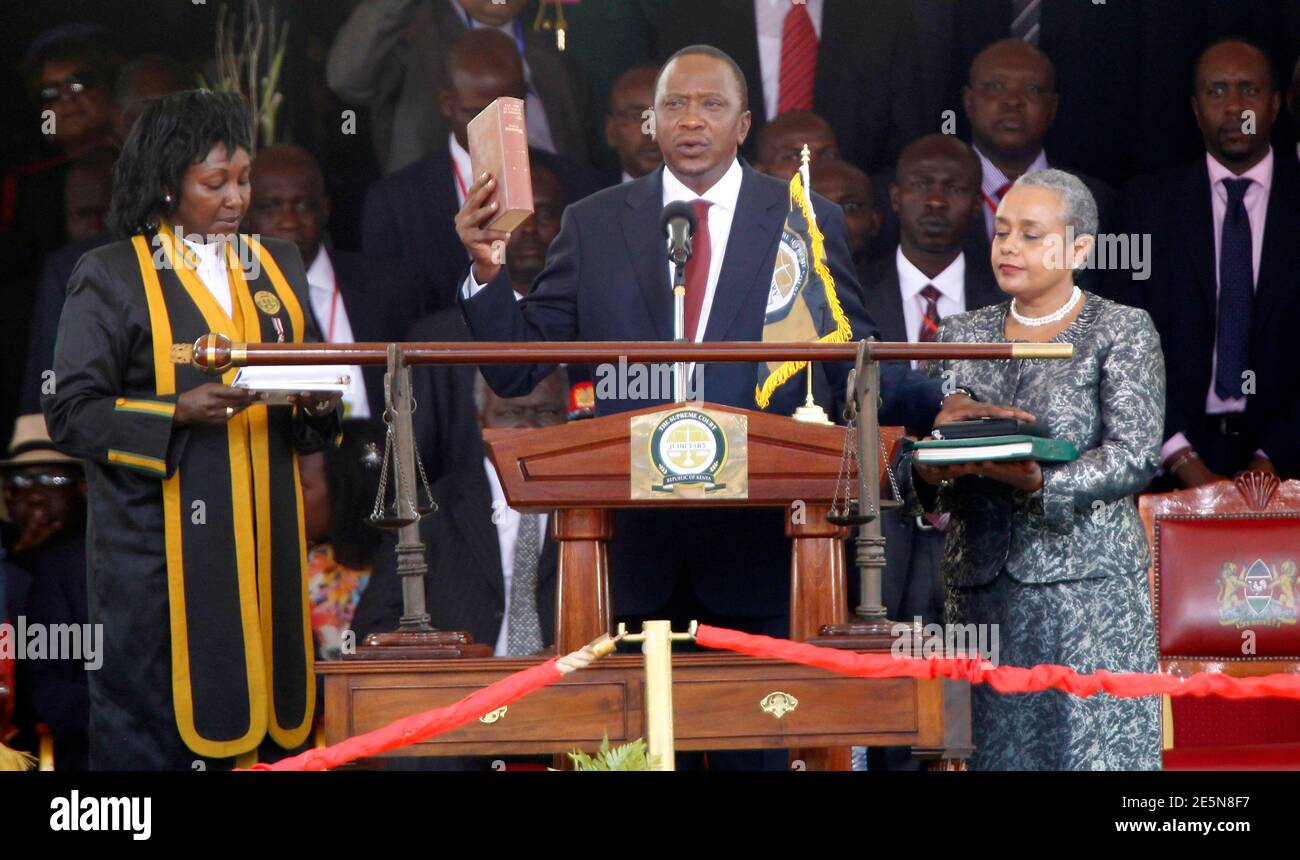 Kenya's President Uhuru Kenyatta takes the oath of office as First Lady Margaret (R) holds a bible during the official swearing-in ceremony at Kasarani Stadium in Nairobi, April 9, 2013. Kenyatta took his oath of office on Tuesday, presenting Western states with a challenge of how to deal with a leader indicted by the International Criminal Court. REUTERS/Thomas Mukoya (KENYA - Tags: POLITICS ELECTIONS PROFILE TPX IMAGES OF THE DAY) Stock Photo