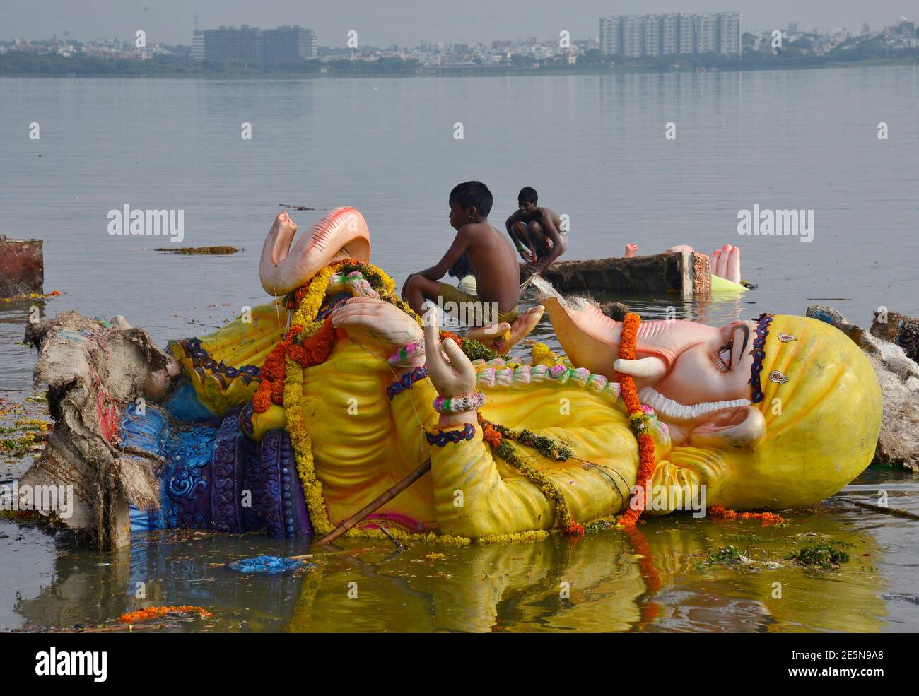 A boy sits on an idol of the Hindu elephant god Ganesh, the deity of prosperity, after it was immersed in the waters of Hussain Sagar lake on Wednesday to mark the A boy sits on an idol of the Hindu elephant god Ganesh, the deity of prosperity, after it was immersed in the waters of Hussain Sagar lake on Wednesday to mark the
