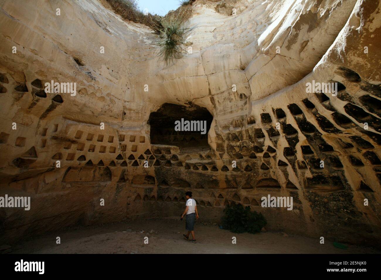A tourist walks inside a columbarium at Hirbet Madras archaeological site, featuring ancient rebel hideouts, at the foothills of Jerusalem around the ancient city of Beit Guvrin August 23, 2011. You'll need a headlamp, a tight waistline and no fear of the dark in order to enjoy one of the most extreme, yet lesser known, archaeological wonders of the Holy Land - Ancient tunnel systems dug by Jewish rebels to fight the Roman empire. Picture taken August 23, 2011. To match Reuters Life! ISRAEL-CAVES/  REUTERS/Baz Ratner (ISRAEL - Tags: SOCIETY TRAVEL) Stock Photo
