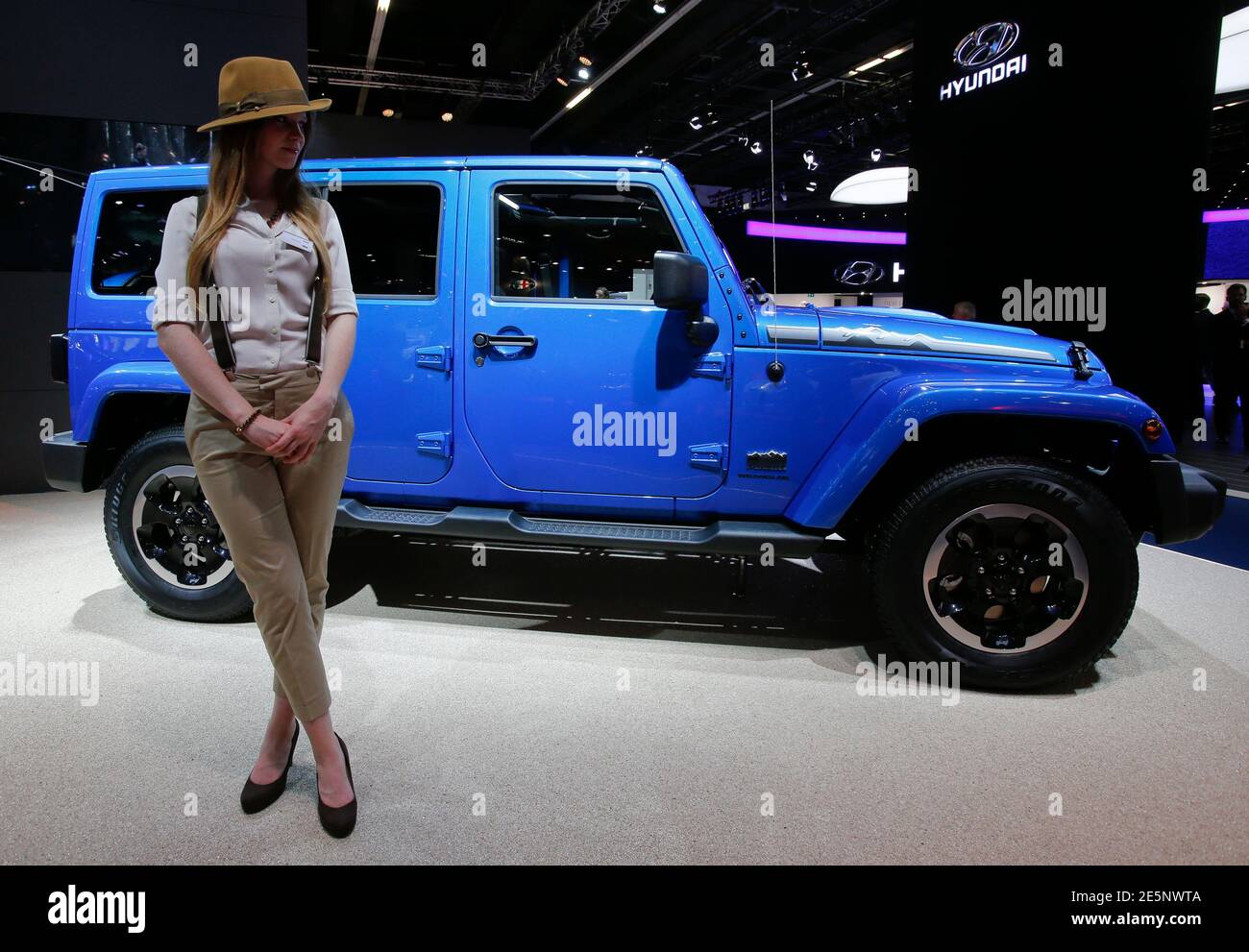 A model poses next to a Jeep Wrangler Unlimited during a media preview day  at the Frankfurt Motor Show (IAA) September 10, 2013. The world's biggest  auto show is open to the