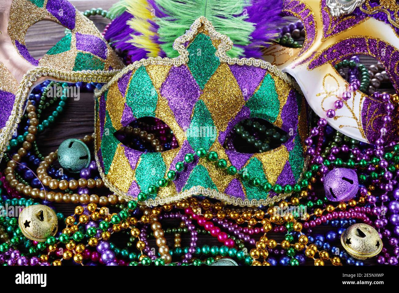 A group of Venetian and New Orlean Mardi gras mask with colorful beads on dark background Stock Photo