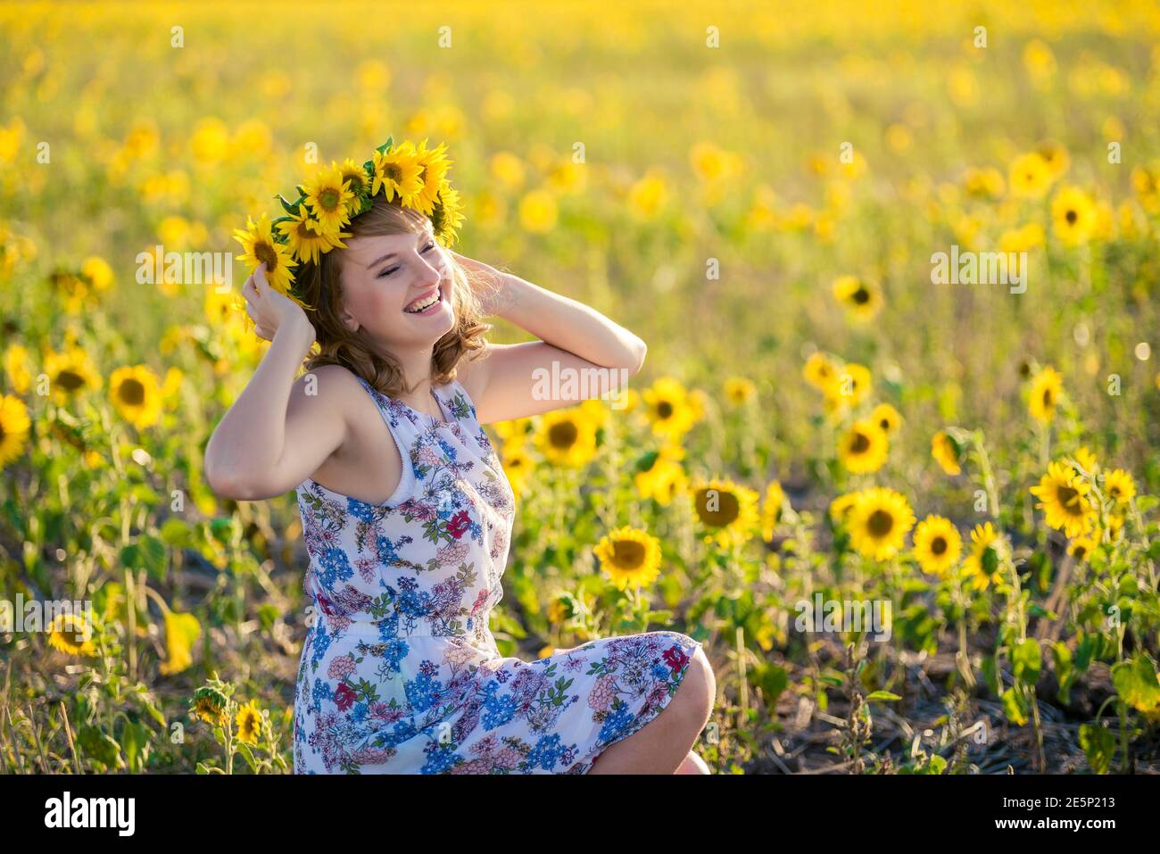 Cute redhaired smiling girl in the field full of sunflowers, wreath of ...