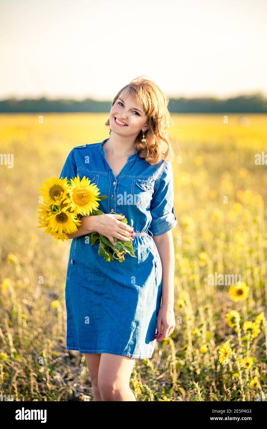 Cute redhaired happy smiling girl in the field full of sunflowers ...