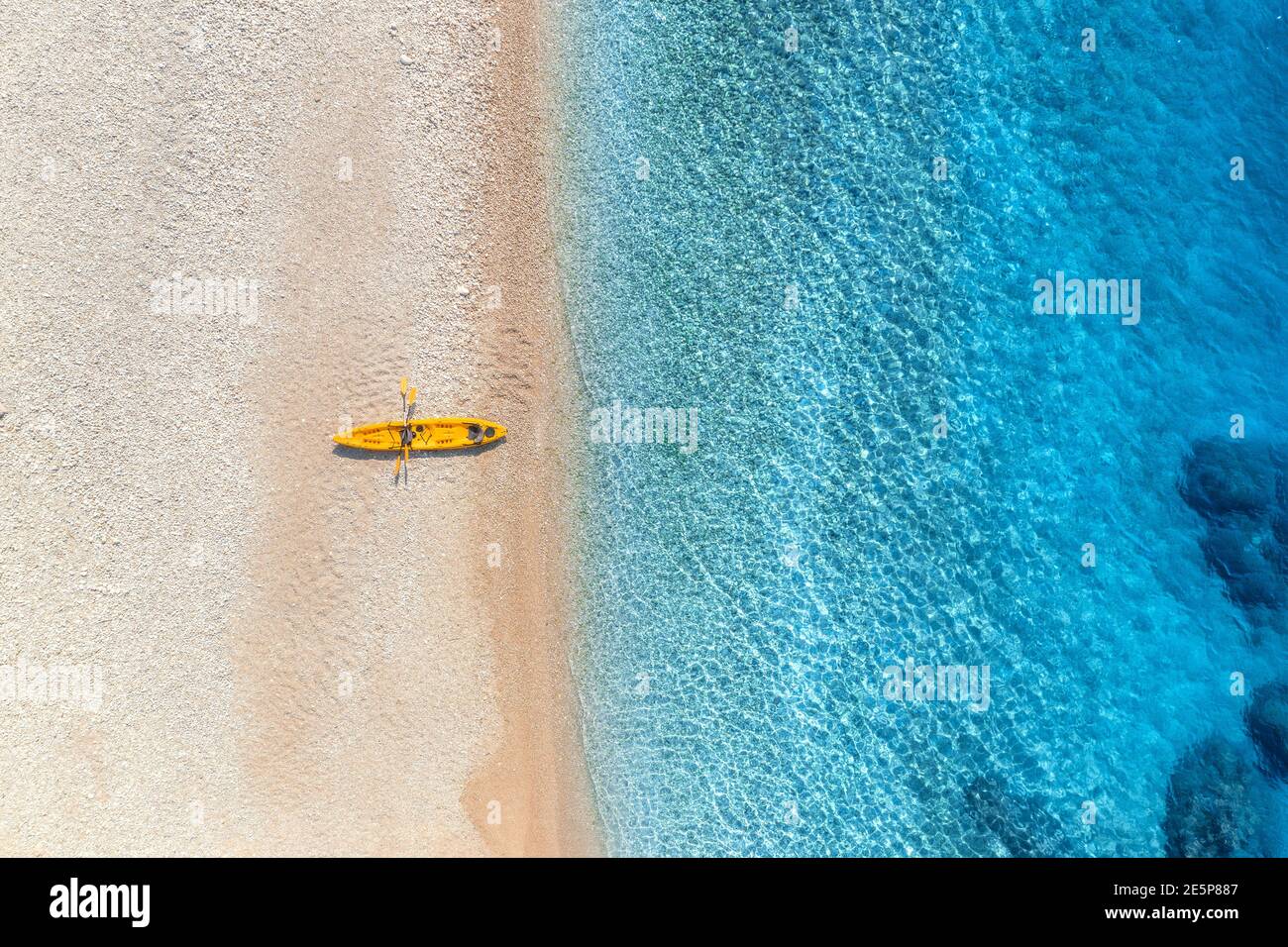 Aerial view of empty sandy beach with yellow canoe Stock Photo