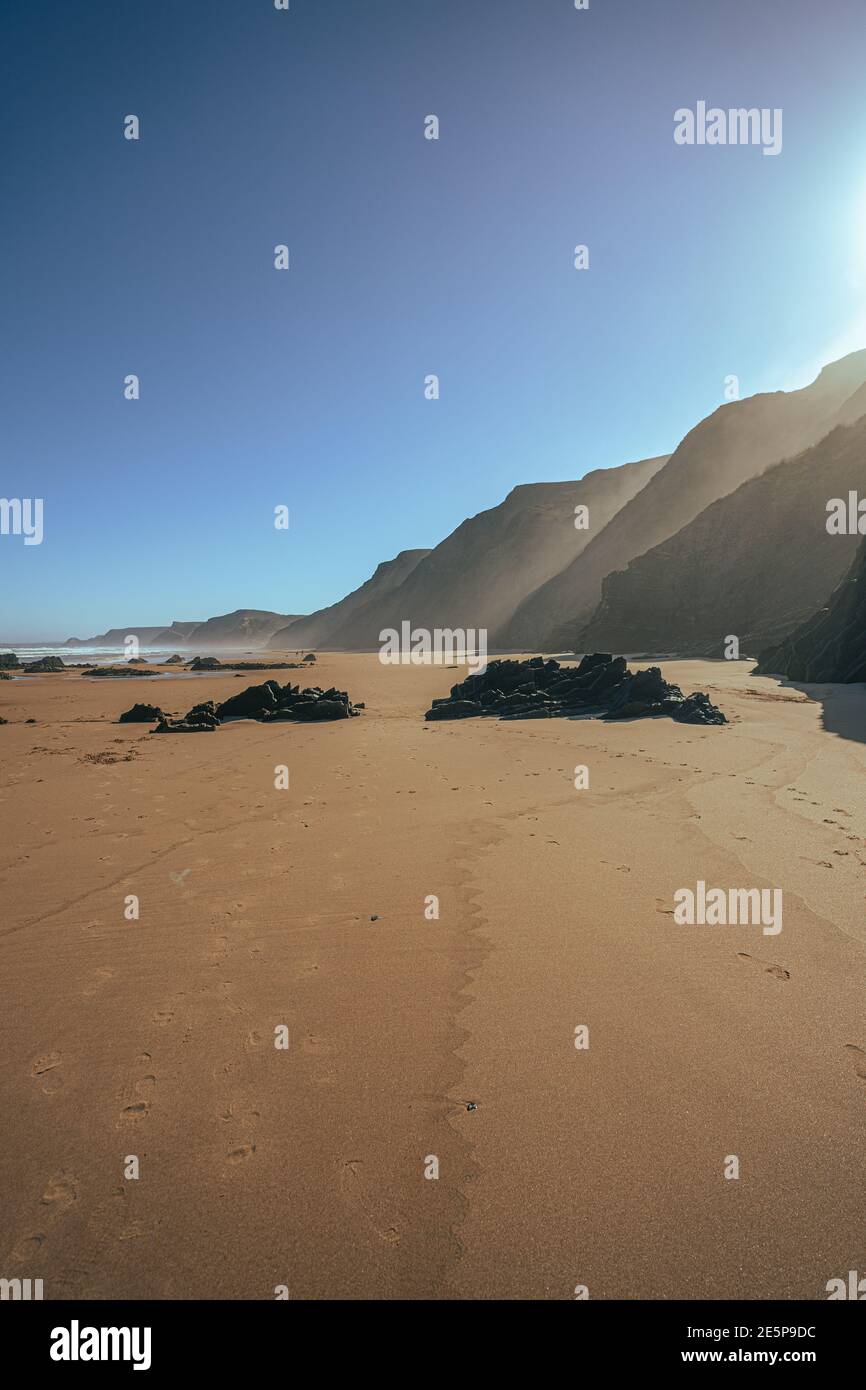 Black rock volcanic formation on sand beach. Square stones on the coast. Portugal, Algarve coastline. Stock Photo
