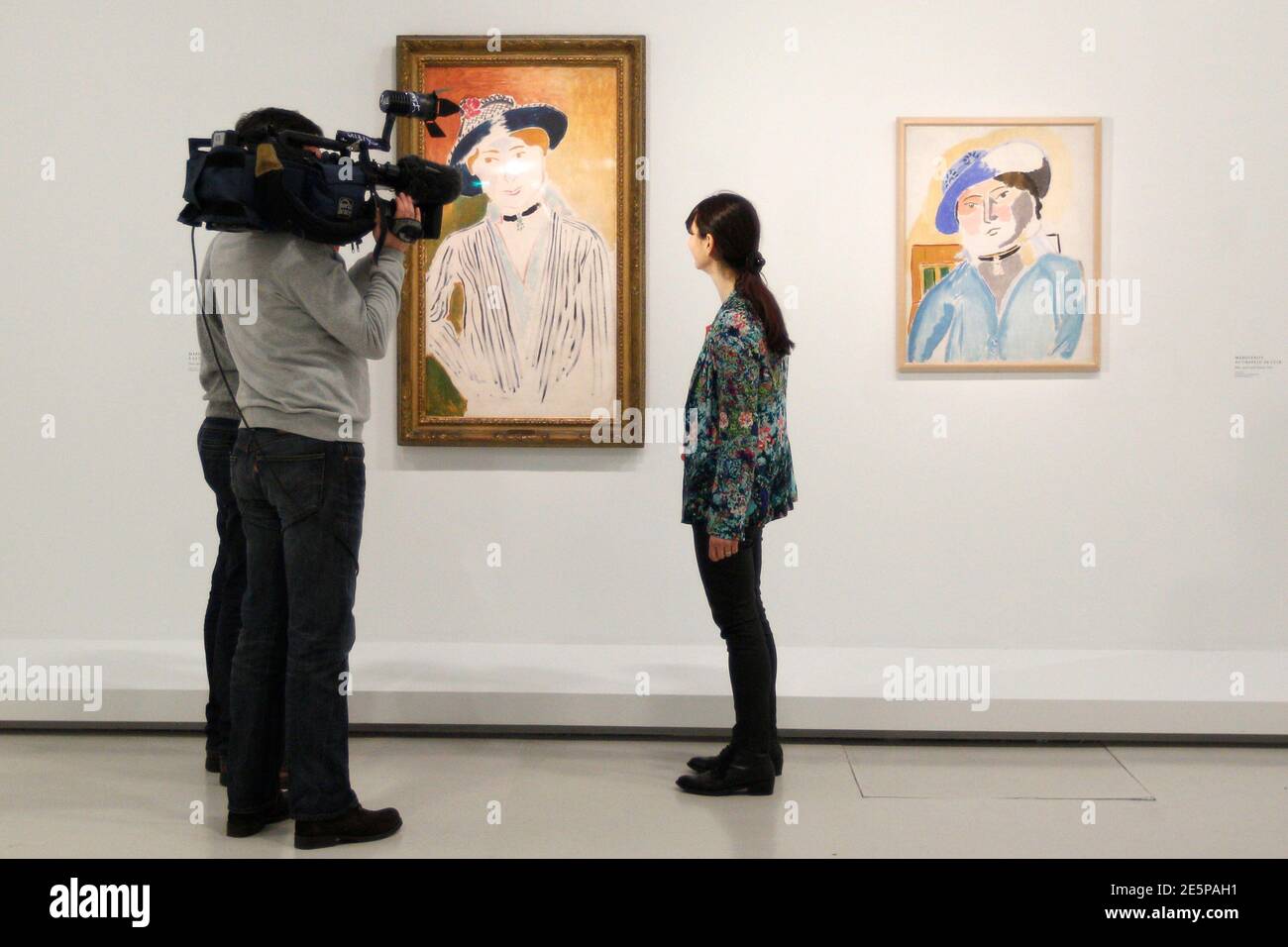Journalists work in front of the paintings "Marguerite a la veste Rayee"  (Striped Jacket, 1914) at L and "Marguerite au Chapeau de cuir" (Marguerite  with a leather hat, 1914) by French painter