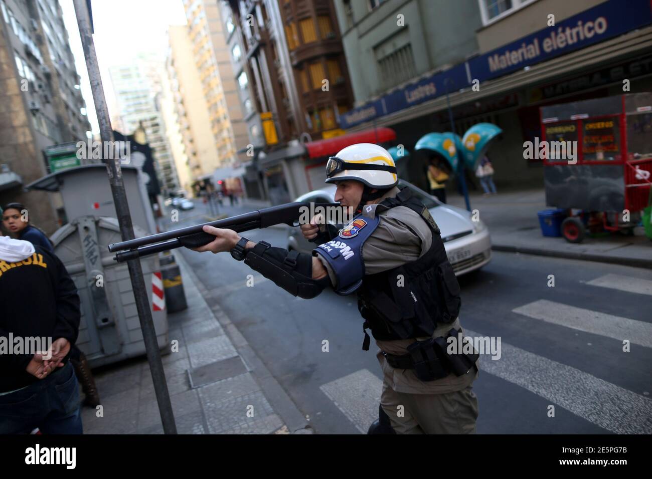 A policeman points his rifle after clashes between demonstrators and police during a protest against the 2014 World Cup in Porto Alegre, June 12 , 2014.   REUTERS/Edgard Garrido (BRAZIL  - Tags: SPORT SOCCER WORLD CUP CIVIL UNREST) Stock Photo