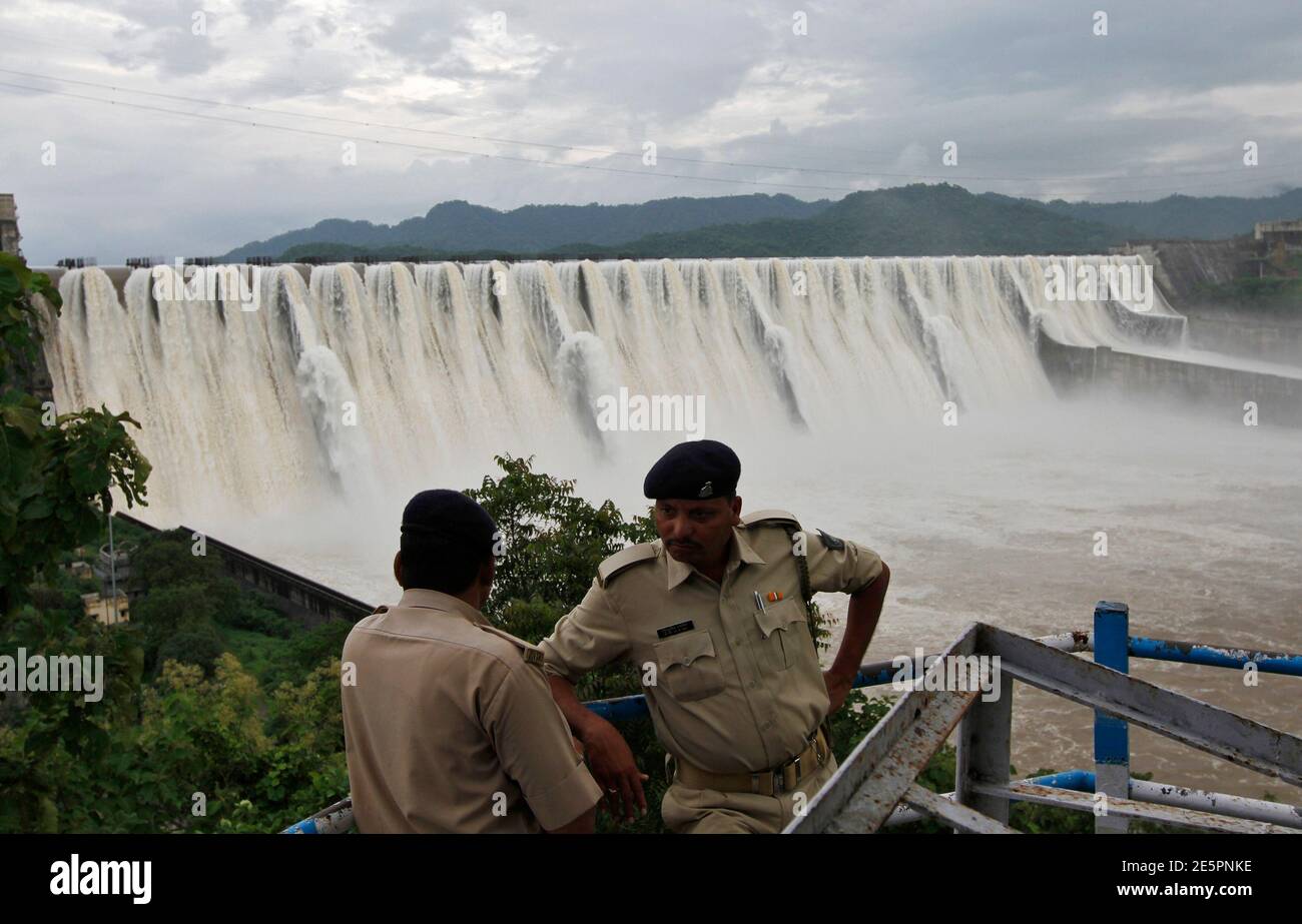 Police stand guard at the overflowing dam in Kavadia, 194 km (121 miles) south of the western Indian city of Ahmedabad, August 29, 2011. The dam was overflowing due to heavy rains in the catchment area and release of water from Indira Sagar dam which is located in the neighbouring Madhya Pradesh state, officials said. Picture taken August 29, 2011. REUTERS/Amit Dave (INDIA - Tags: BUSINESS ENERGY CRIME LAW) Stock Photo