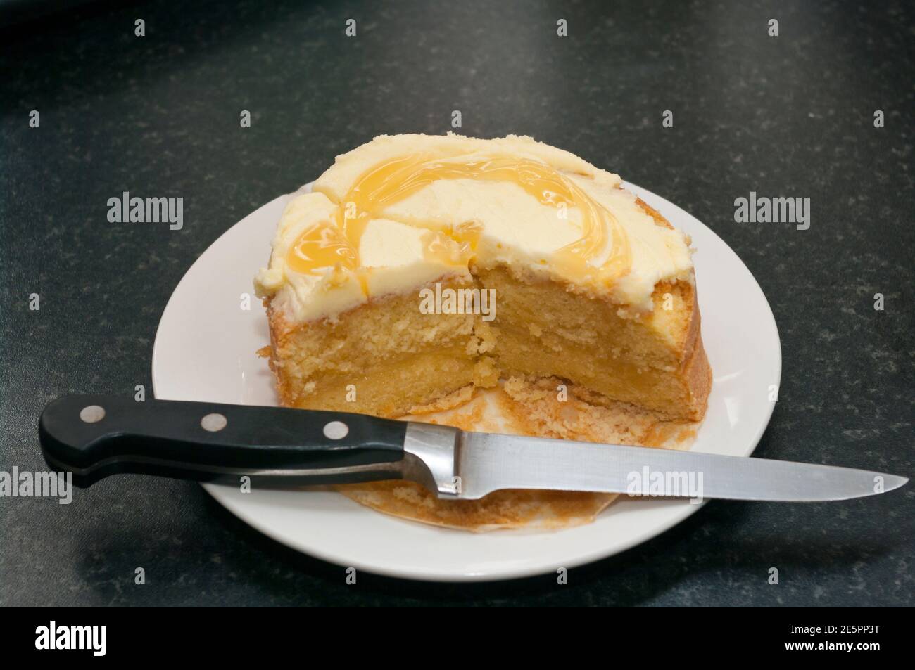 Sliced Cut Lemon Cake On A White Plate With A Knife Stock Photo