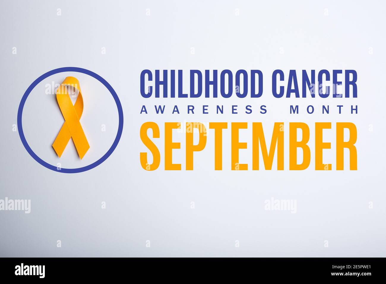 Childhood cancer awareness month. September. Yellow handmade awareness paper ribbon on white background. Stock Photo