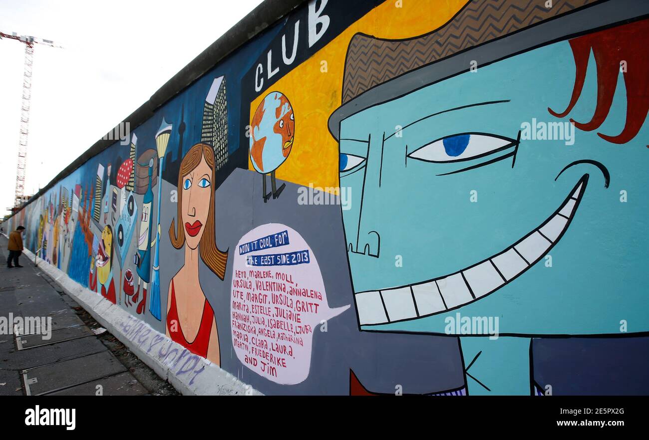 A person looks at the newly painted artwork of contemporary German Pop artist Jim Avignon at the open air 0.8-mile painted section of the Berlin Wall known as the 'East Side Gallery' in Berlin October 21, 2013. Over the weekend Avignon painted over his original 1990 mural 'Doin It Cool For The East Side', during a performance.  Picture taken with a fish-eye lens  REUTERS/Fabrizio Bensch (GERMANY - Tags: SOCIETY ENTERTAINMENT CITYSPACE) Stock Photo