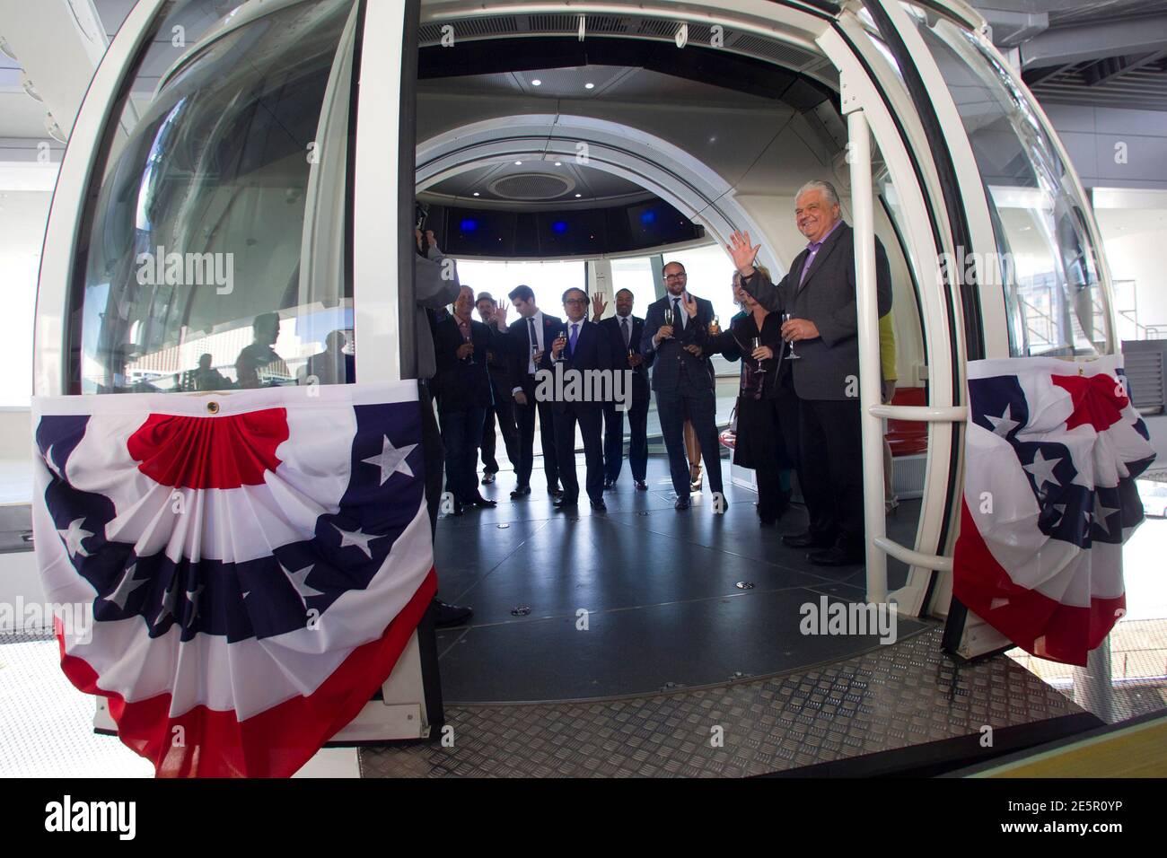 Special guests, executives and elected officials enter a cabin for the first official ride on the 550-foot-tall High Roller observation wheel in Las Vegas, Nevada March 31, 2014. Clark County Commission Chairman Steve Sisolak waves at right. The observation wheel, the tallest in the world, is part of the Linq project, a $550 million development by Caesars Entertainment Corp. The ride opened to the public on Monday. REUTERS/Las Vegas Sun/Steve Marcus (UNITED STATES - Tags: SOCIETY ENTERTAINMENT BUSINESS) Stock Photo