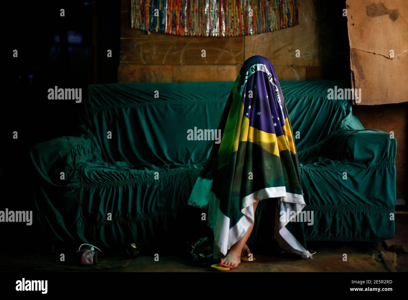 Camile Maria Souto, 3, plays with a Brazilian flag during the 2014 World Cup round of 16 game between Brazil and Chile in her family home in the Sobradinho working class neighborhood of Brasilia June 28, 2014.    REUTERS/Ueslei Marcelino (BRAZIL  - Tags: SPORT SOCCER WORLD CUP SOCIETY) Stock Photo