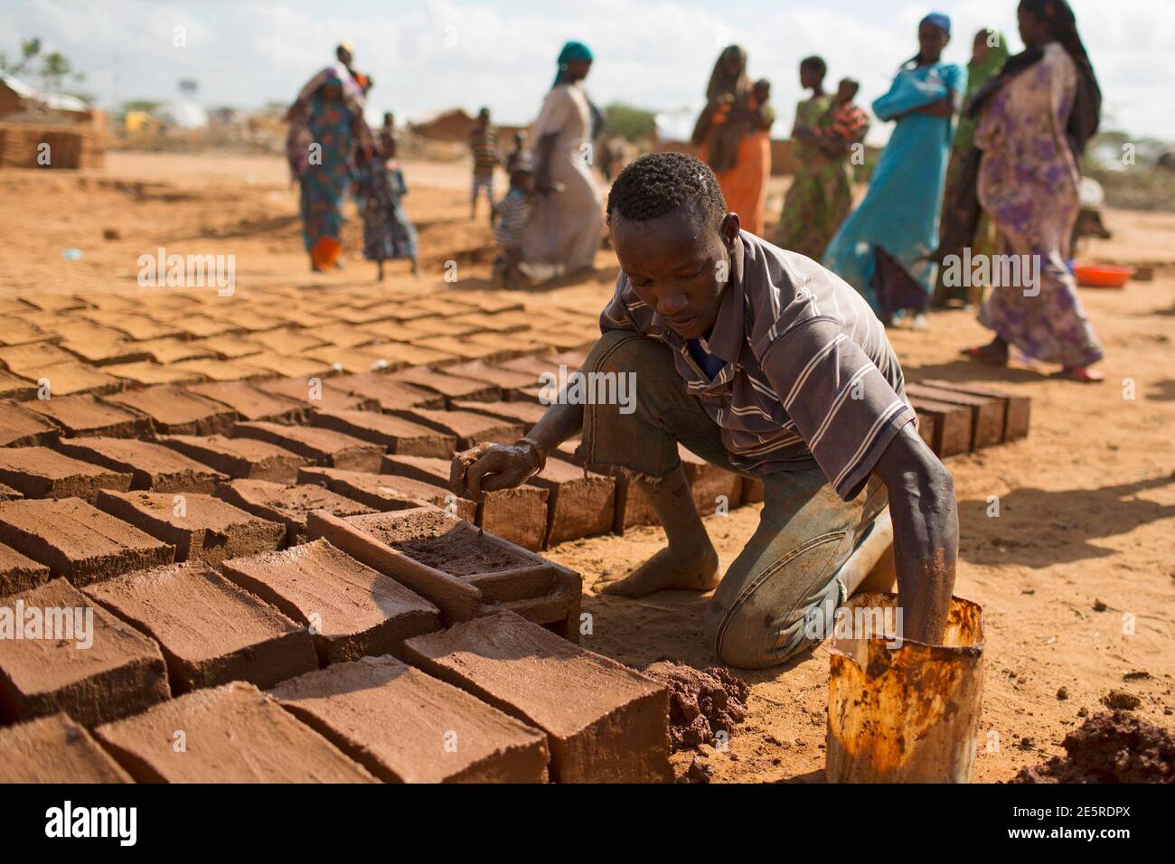A man makes construction bricks from mud at one of several refugee settlements in Dadaab, Garissa County, northeastern Kenya October 9, 2013.  REUTERS/Siegfried Modola  (KENYA - Tags: SOCIETY) Stock Photo
