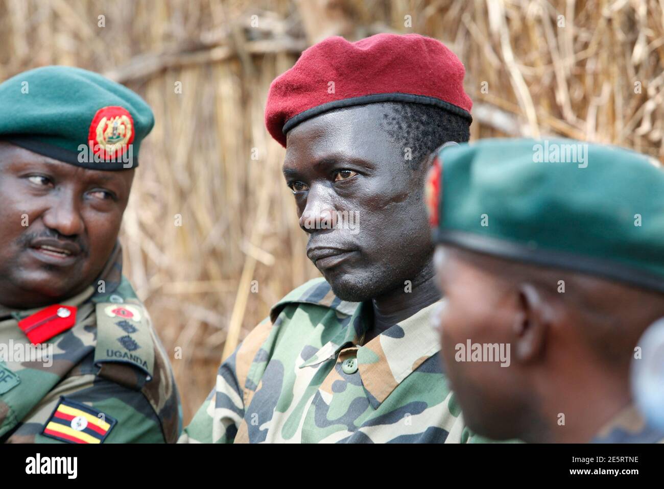 Lord's Resistance Army (LRA) commander Caesar Achellam (C) sits next to Uganda army spokesman Felix Kulyije (R) as he is presented to the media in Djema May 13, 2012, after he was captured by Ugandan soldiers tracking down LRA fugitive leaders at a forest bordering the Central African Republic (CAR) and the Democratic Republic of Congo. Uganda captured Achellam, one of the top five members of the LRA, bringing it a step closer to catching Joseph Kony, the notorious rebel leader accused of war crimes, the military said on Sunday. REUTERS/James Akena (CENTRAL AFRICAN REPUBLIC - Tags: MILITARY PO Stock Photo