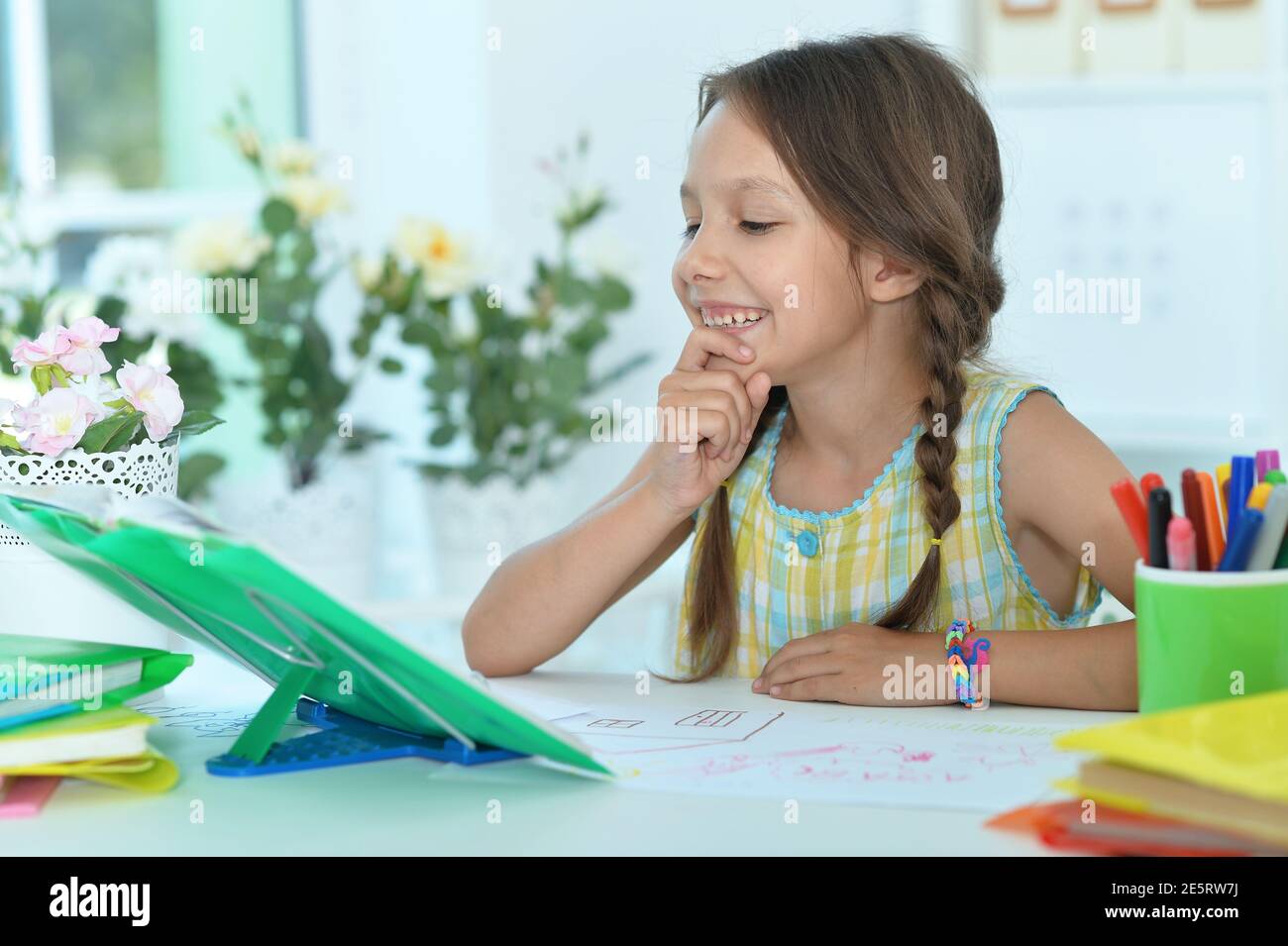 Portrait of cute little girl studying at home Stock Photo - Alamy