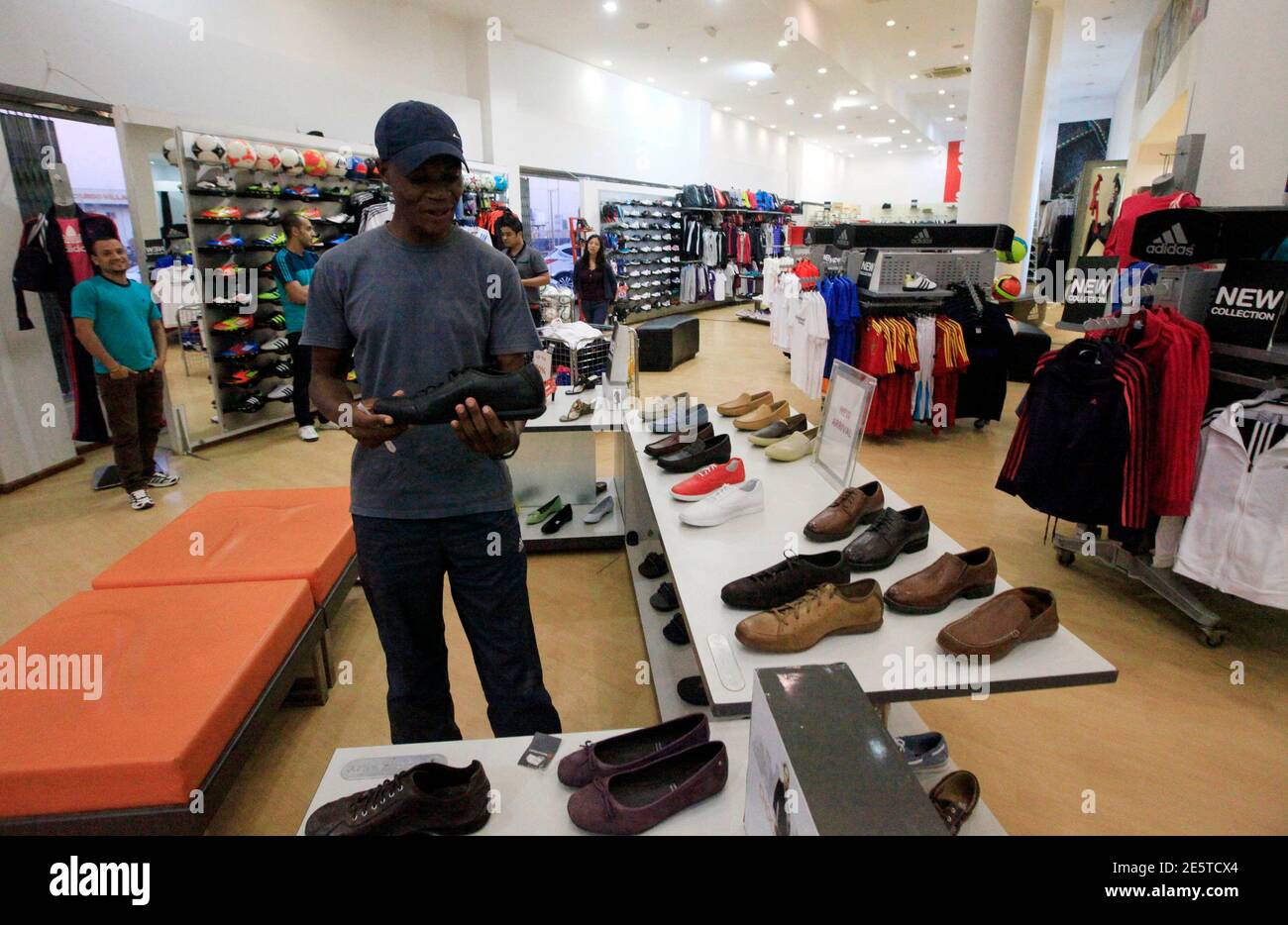 A customer looks at shoes at an Adidas shop in Khartoum, November 29, 2012.  Ambitious plans backed by Gulf Arab investors were drawn up when the  economy started to accelerate, driven by