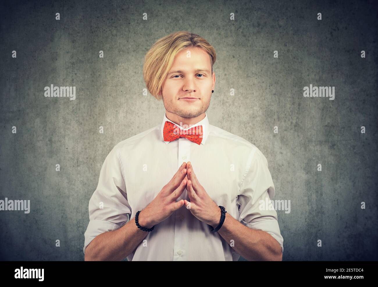 Sneaky scheming young man looking at camera Stock Photo