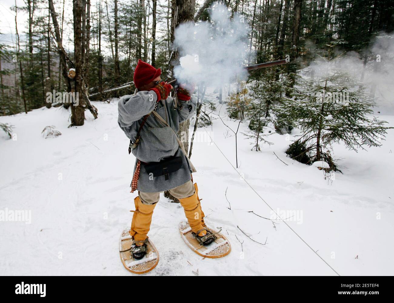 A man fires his rifle as he competes in the Primitive Biathlon in Dalton, New Hampshire February 16, 2013. The Dalton Gang, a single action shooting club, holds the annual Primitive Biathlon in which competitors wear snowshoes and fire single shot muzzle loaded firearms at four stations along a 1.75 mile course. REUTERS/Jessica Rinaldi (UNITED STATES - Tags: SOCIETY SPORT) Stock Photo