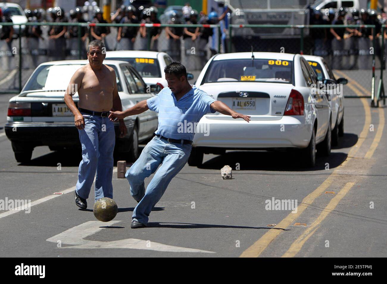 Taxi drivers play soccer during a strike outside the presidential house in Tegucigalpa February 28, 2011. The taxi drivers are demanding the government of President Porfirio Lobo pay a bonus to offset rising fuel prices, according to the Honduran Association of taxi drivers (ATAXISH). According to the Deputy Minister of Industry and Trade Juan Jose Cruz, the rise in fuel prices is due to the political crisis in the Middle East.  REUTERS/Edgard Garrido   (HONDURAS - Tags: POLITICS CIVIL UNREST TRANSPORT) Stock Photo
