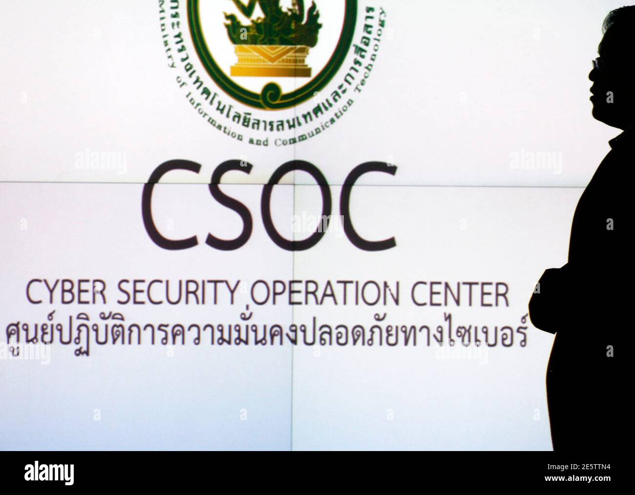 A man is silhouetted against a screen at the cyber security operation centre in Bangkok December 1, 2011. From a windowless room in a Bangkok suburb, computer technicians scour thousands of websites, Facebook pages and Tweets night and day. Their mission: to suppress what is regarded as one of Thailand's most heinous crimes -- insulting the monarchy. The government calls it its 'war room', part of a zero-tolerance campaign that uses the world's most draconian lese-majeste laws to stamp out even the faintest criticism of 84-year-old King Bhumibol Adulyadej, the world's longest-reigning monarch. Stock Photo