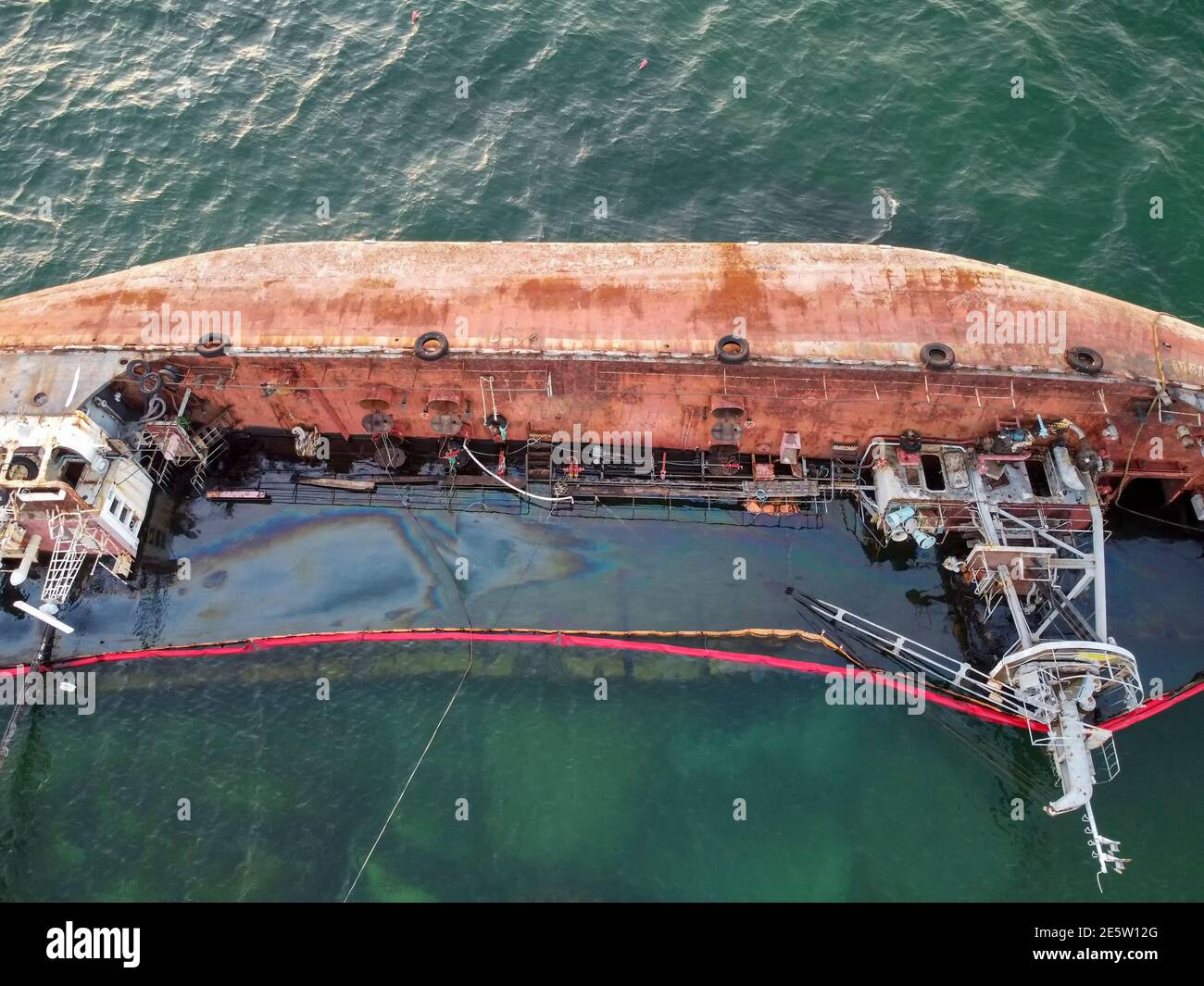 Sunken rusty tanker lying on the washed-up seas off the coast. Stock Photo