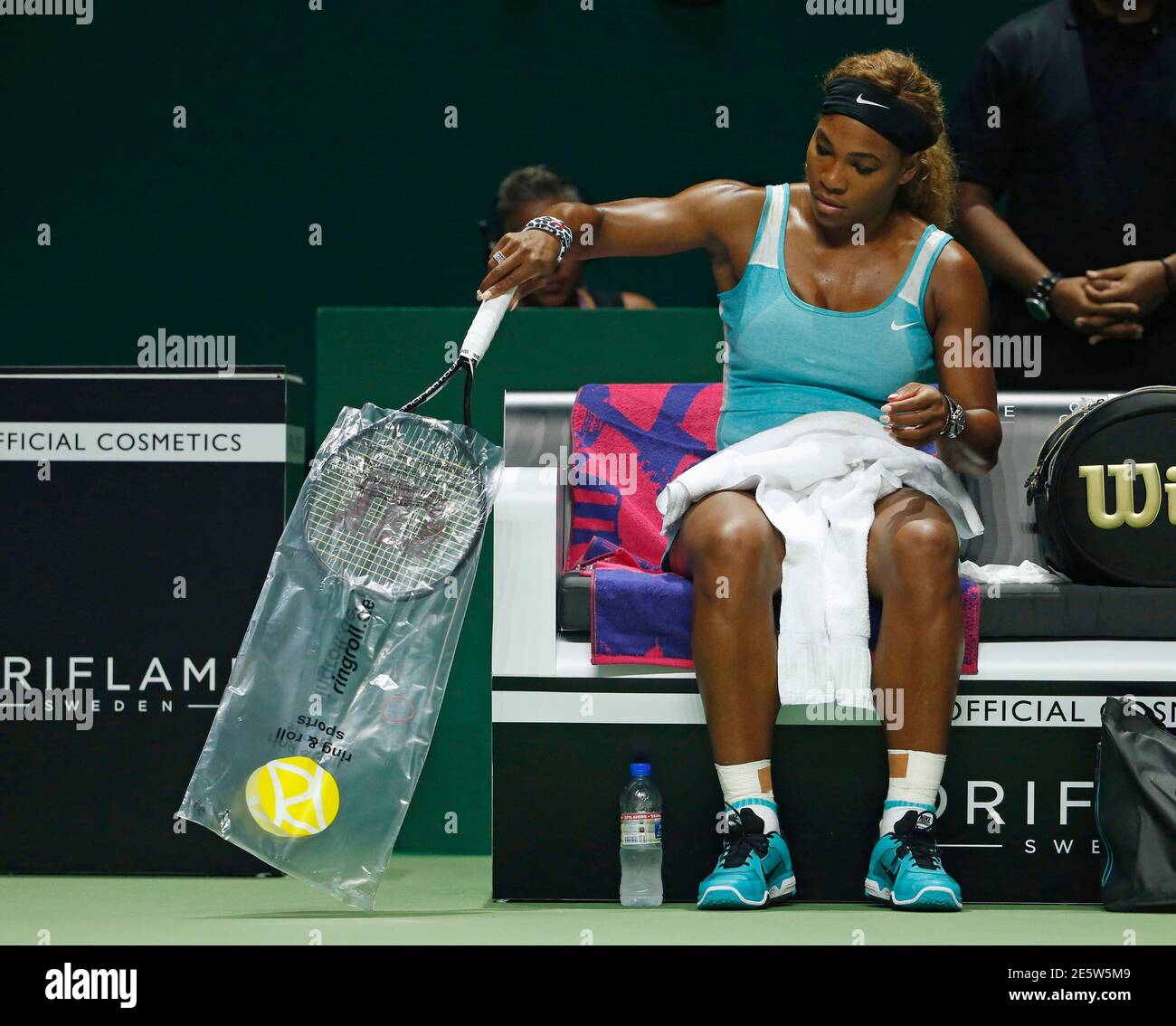 Serena Williams of the U.S. takes the plastic cover off her third racket after smashing her first two, during her WTA Finals singles semi-final tennis match against Caroline Wozniacki of Denmark at the Singapore Indoor Stadium October 25, 2014. REUTERS/Edgar Su (SINGAPORE - Tags: SPORT TENNIS) Stock Photo