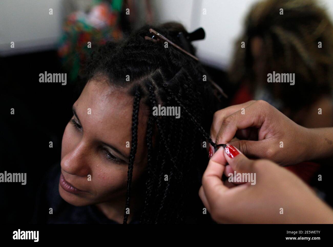 A woman braids her hair at a hair salon in a local market in Rio de Janeiro  November 17, 2012. Brazil will celebrate the annual Black Consciousness Day  on November 20. Picture